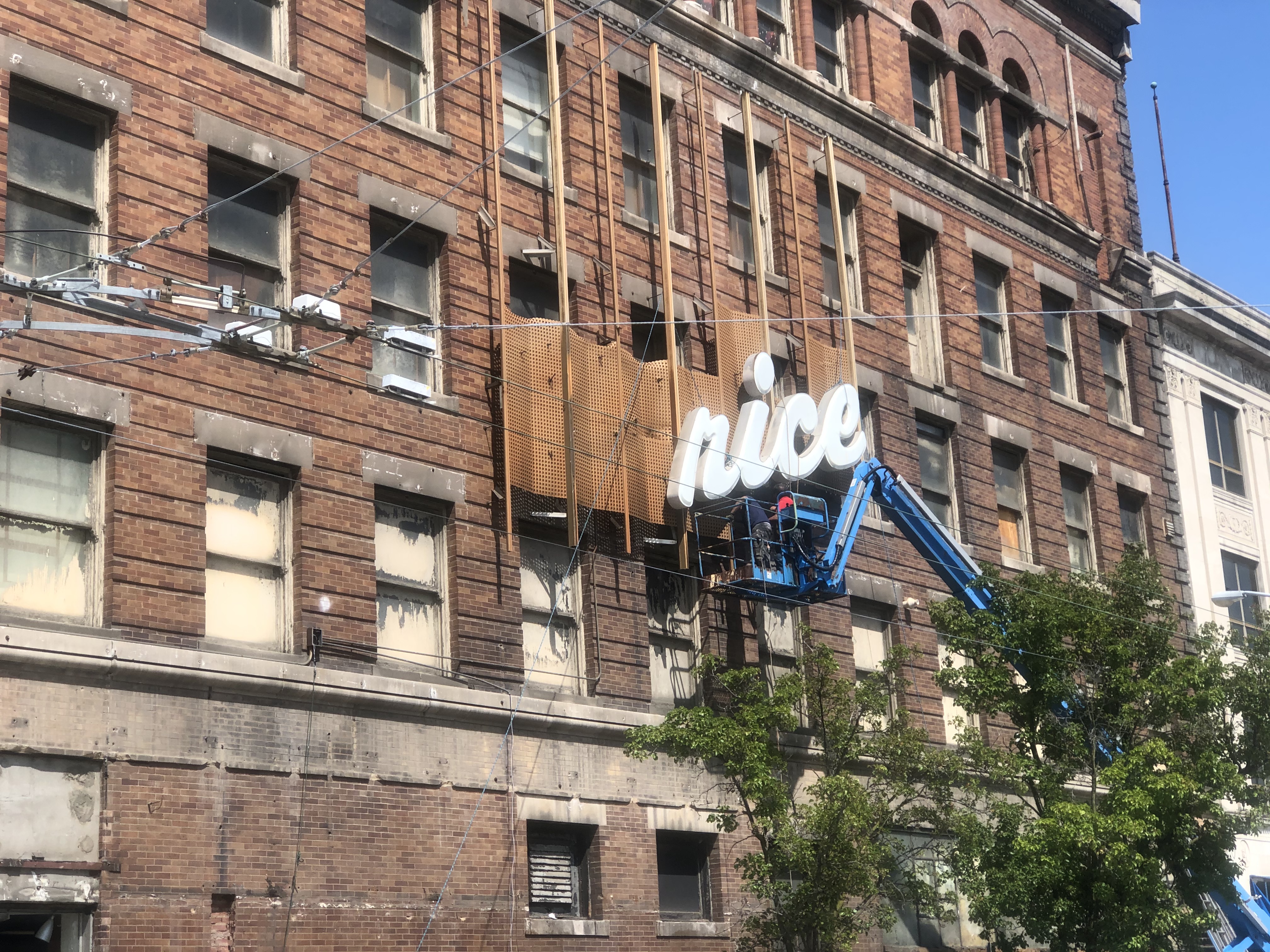 Crews remove aluminum covering the original exterior of the Price Stores building on South Jefferson Street. CORNELIUS FROLIK / STAFF