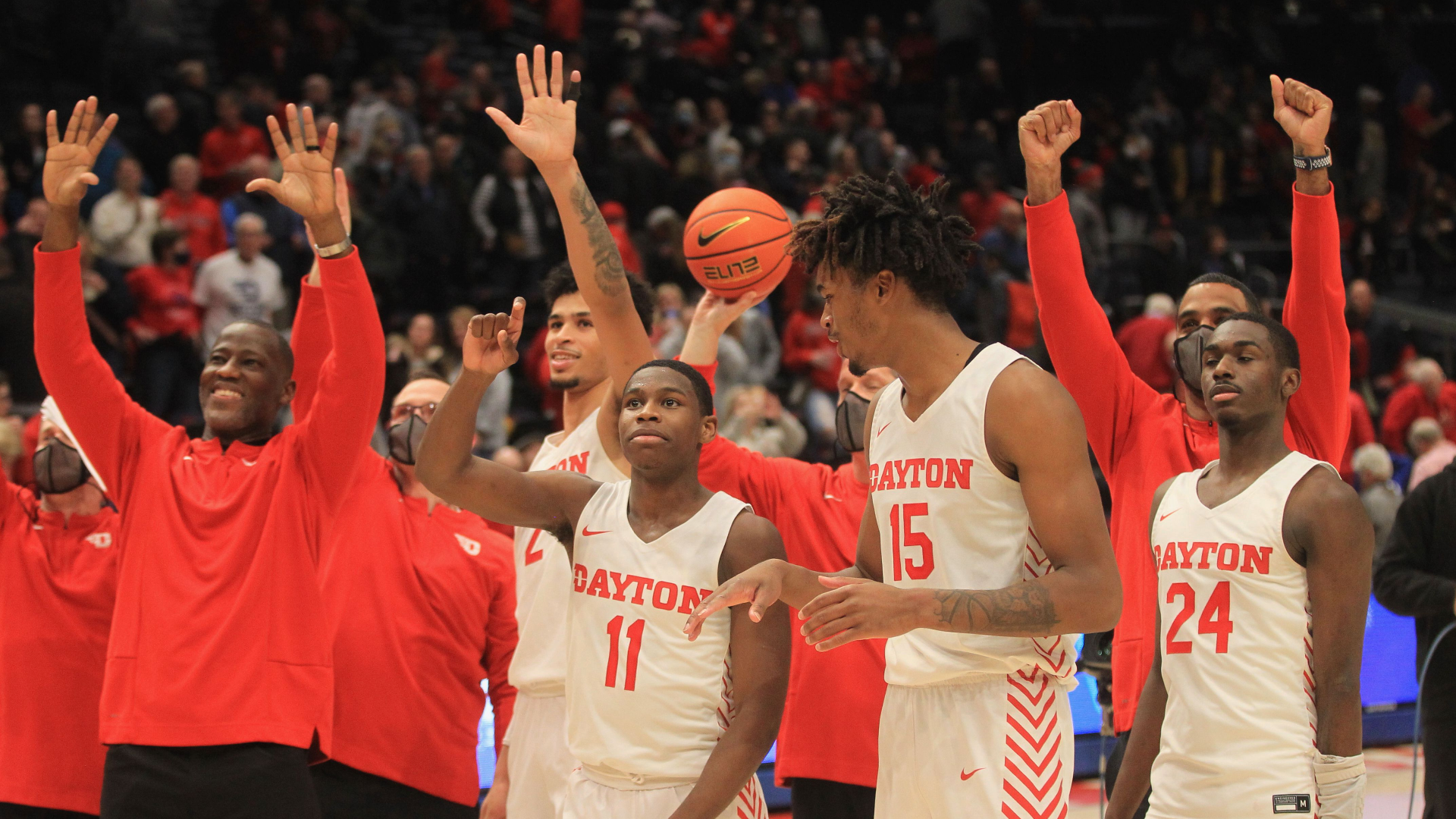 Dayton coach Anthony Grant, left, and players wave to Dayton basketball legend Bucky Bockhorn after a victory against St. Bonaventure on Tuesday, Jan. 18, 2022, at UD Arena. David Jablonski/Staff
