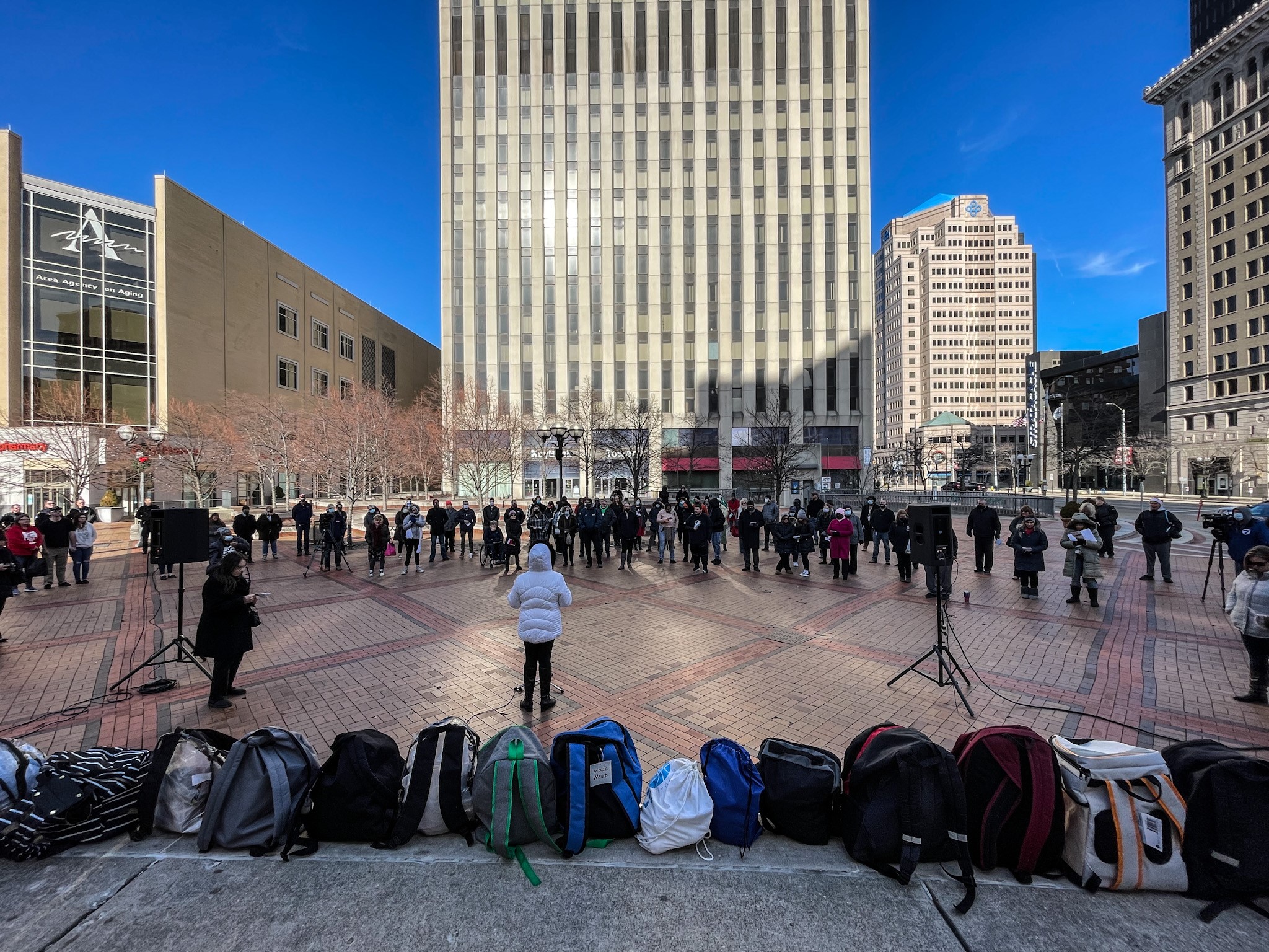 Backpacks filled with items for Dayton's homeless population line the stage on Courthouse Square at a December memorial. JIM NOELKER/STAFF
