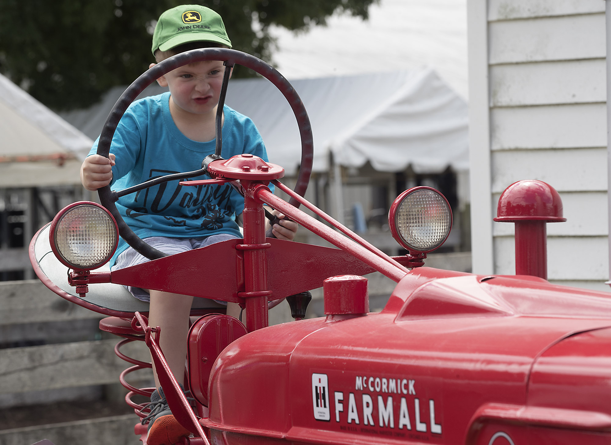 Ethan Napier, 4, pretends to drive a tractor Tuesday at the Champaign County Fair. BILL LACKEY/STAFF