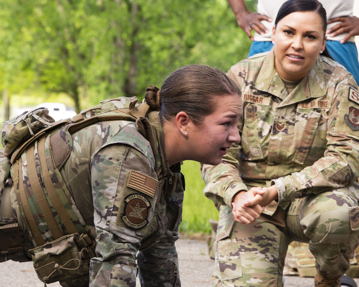 Airman 1st Class Hannah Browning tests her physical endurance in the pushup competition May 16 while Tech. Sgt. Olivia Riggar gives encouragement during the Defenders Challenge, part of National Police Week at Wright-Patterson Air Force Base. U.S. AIR FORCE PHOTO/JAIMA FOGG