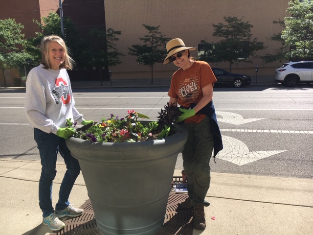 Volunteers work on sidewalk planters on North Ludlow Street Monday morning.