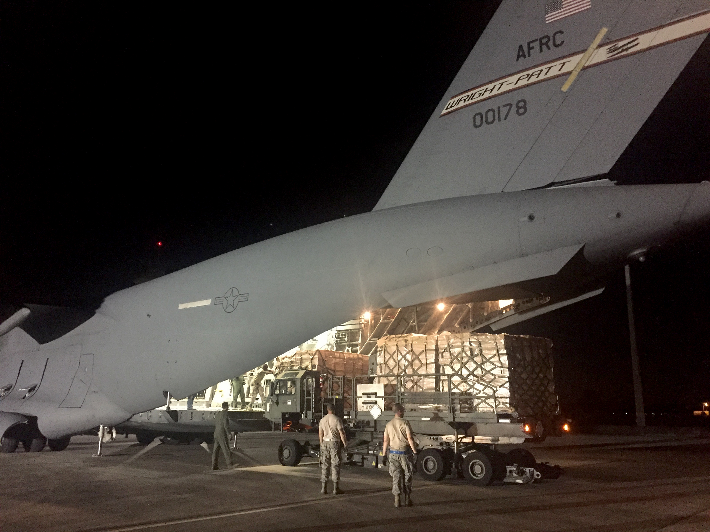 A Wright-Patterson Air Force Reserve C-17 crew unloads hurrican relief supplies at Homestead Air Reserve Base in Florida Tuesday night. BOB GARLOCK / STAFF