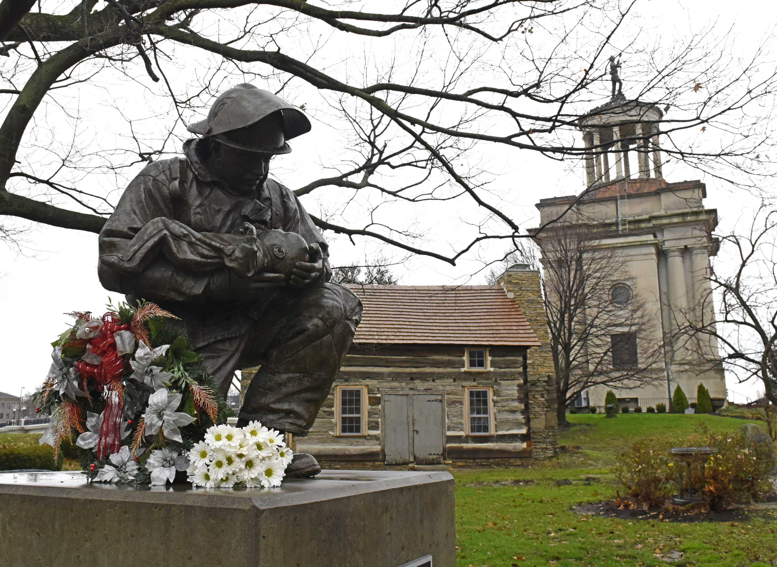 Patrick Wolterman died Monday from injuries he sustained while battling a blaze in a Hamilton home, according to Fire Chief Steve Dawson. Flowers were placed Monday at the foot of the Butler County Fallen Firefighter and EMS Provider Memorial statue on Monument Avenue in Hamilton. NICK GRAHAM/STAFF