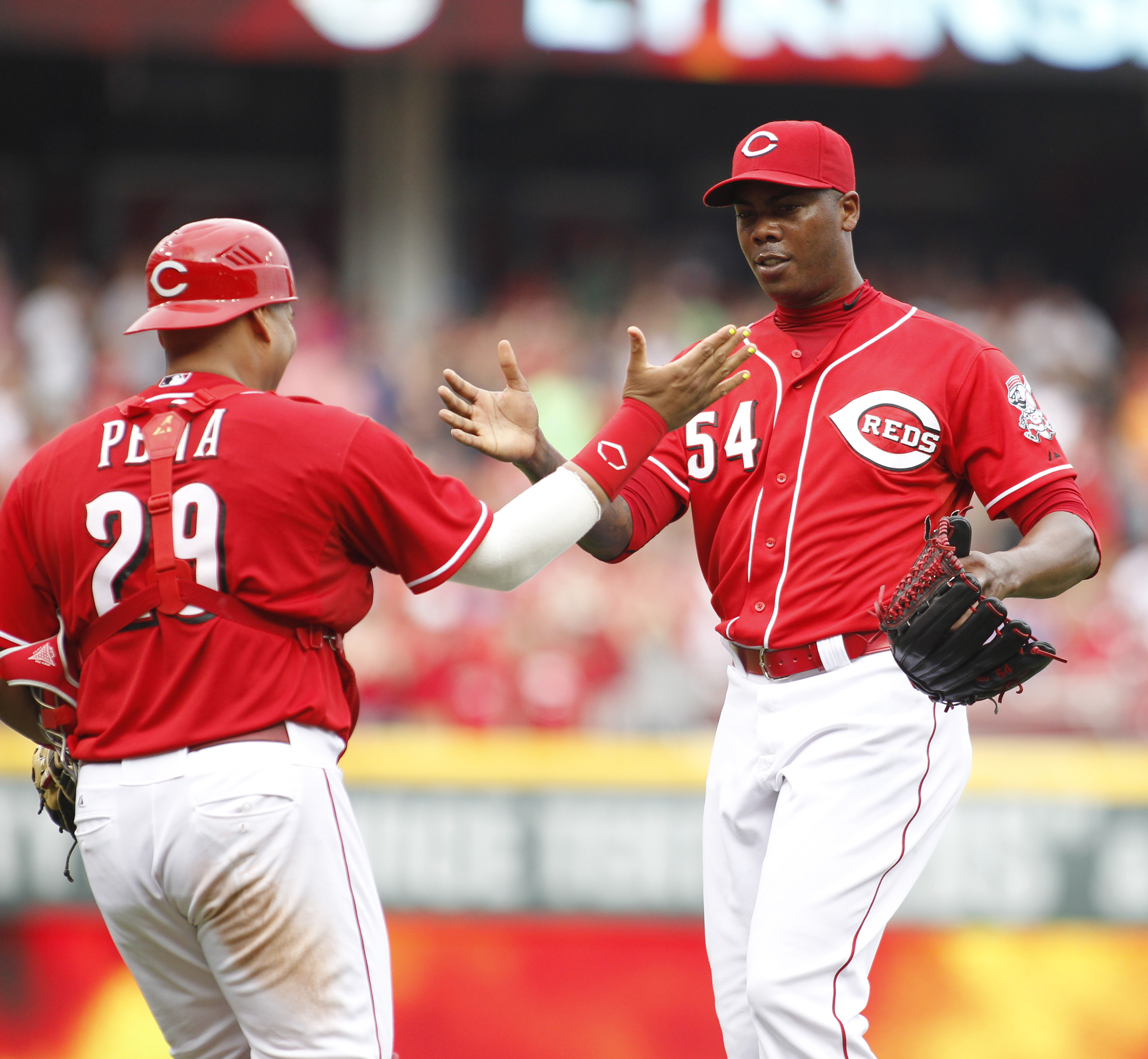 Reds catcher Brayan Pena, left, and closer Aroldis Chapman shake hands after beating the Nationals on Saturday, July 26, 2014, at Great American Ball Park in Cincinnati.