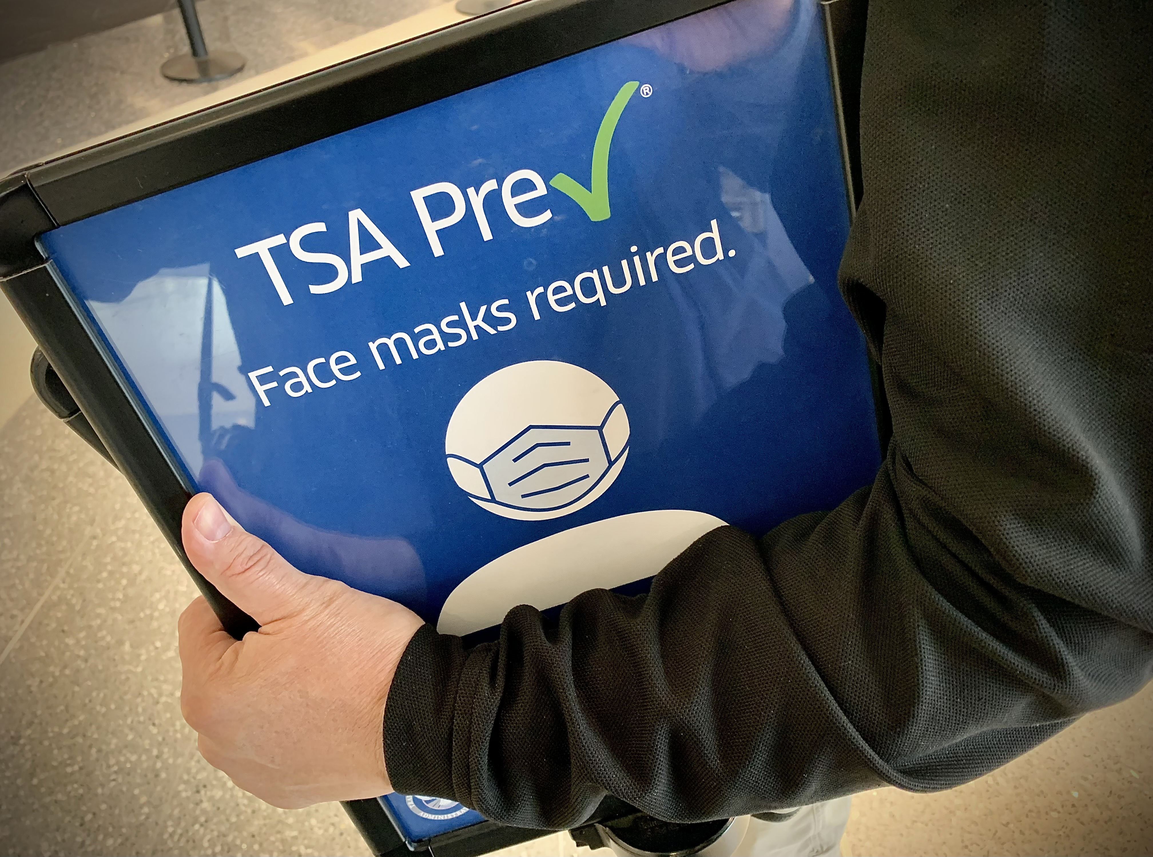 TSA employees remove Face mask required signs Tuesday April 19, 2022 at the Dayton International Airport. A federal judge struck down mask mandates for buses, planes and other public transportation. MARSHALL GORBY\STAFF