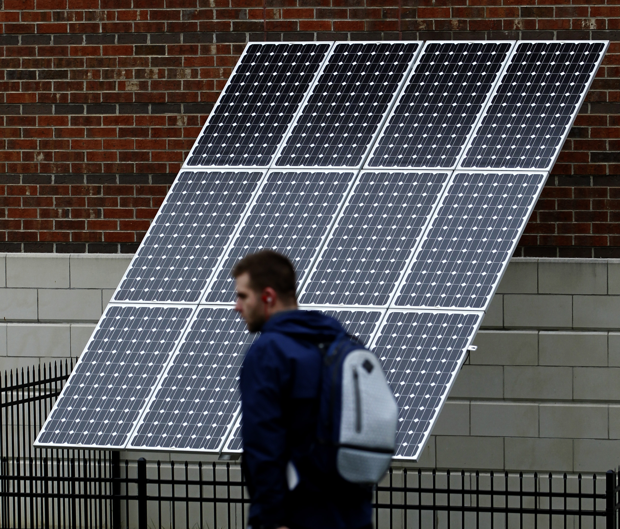 Solar industry employment in Ohio is growing, according to a new national report. In this 2015 photo, a University of Dayton student walks past a solar array outside the campus RecPlex. LISA POWELL / STAFF