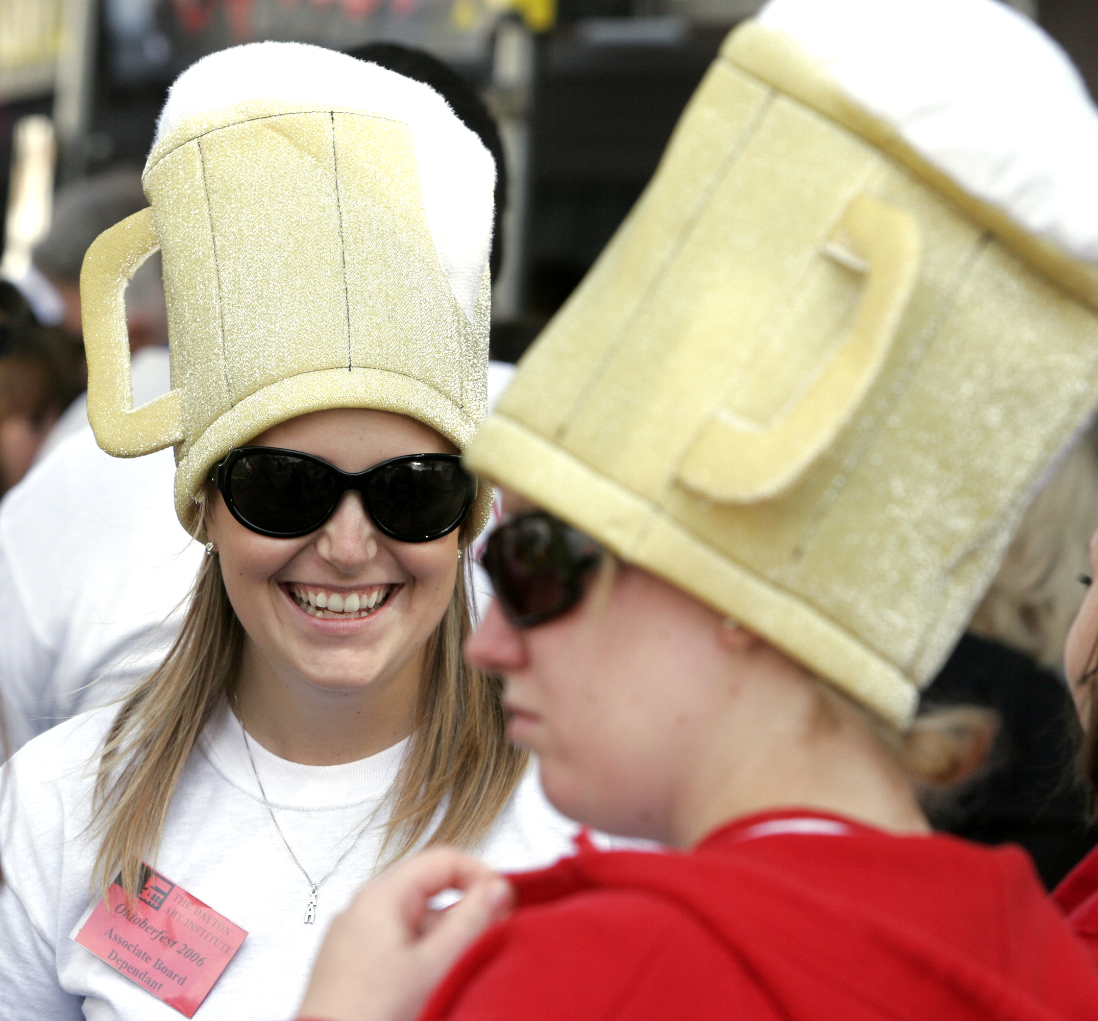 Volunteers Aleena Rorapaugh, left, and Mary Beth Lintz wore beer mug hats to attact attention to their photo business at the Dayton Art Insitute's Oktoberfest.