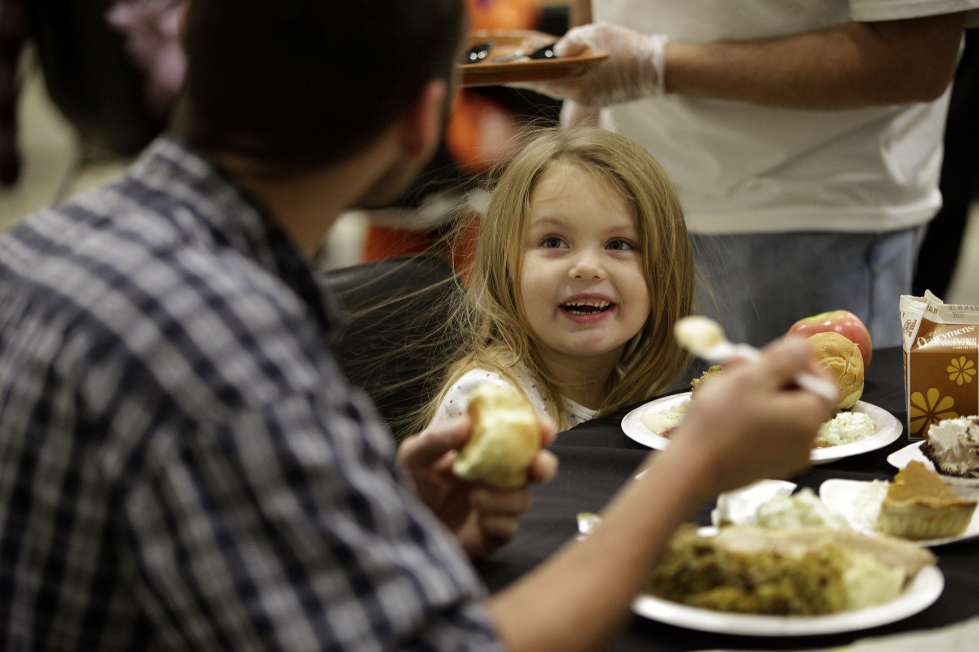 Faith Marie Oakes, 4, enjoys dinner with her father Eric Anders of Dayton during the Feast of Giving, an annual event held each Thanksgiving Day at the Dayton Convention Center. LISA POWELL / STAFF PHOTO