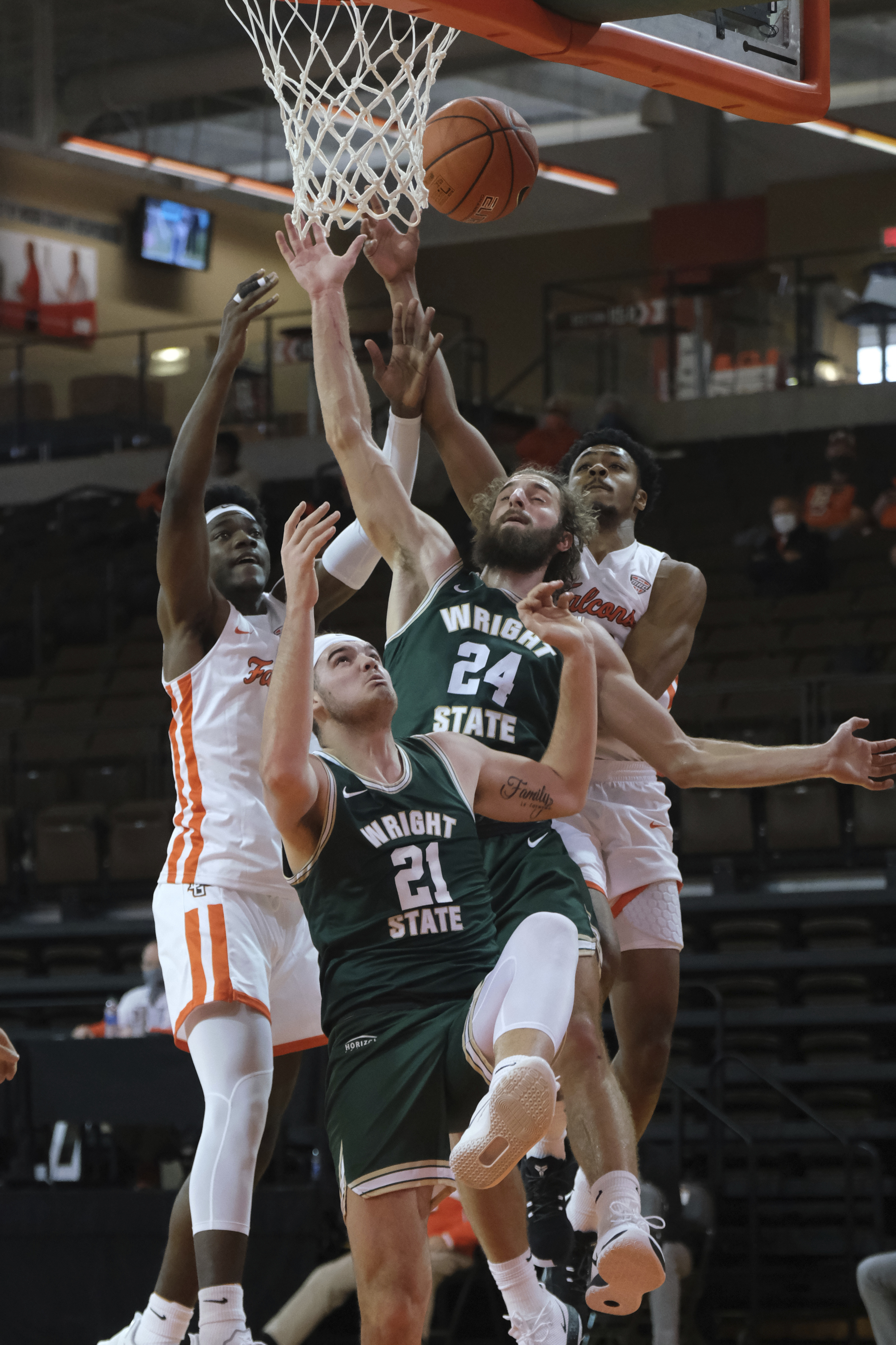 Bowling Green's Cam Young, right, and Jacob Washington, left, battle for a rebound against Wright State's Tim Finke (24) and Grant Basile (21) during the first half of an NCAA college basketball game Sunday, Dec. 13, 2020, in Bowling Green, Ohio. (J.D. Pooley/Sentinel-Tribune via AP)