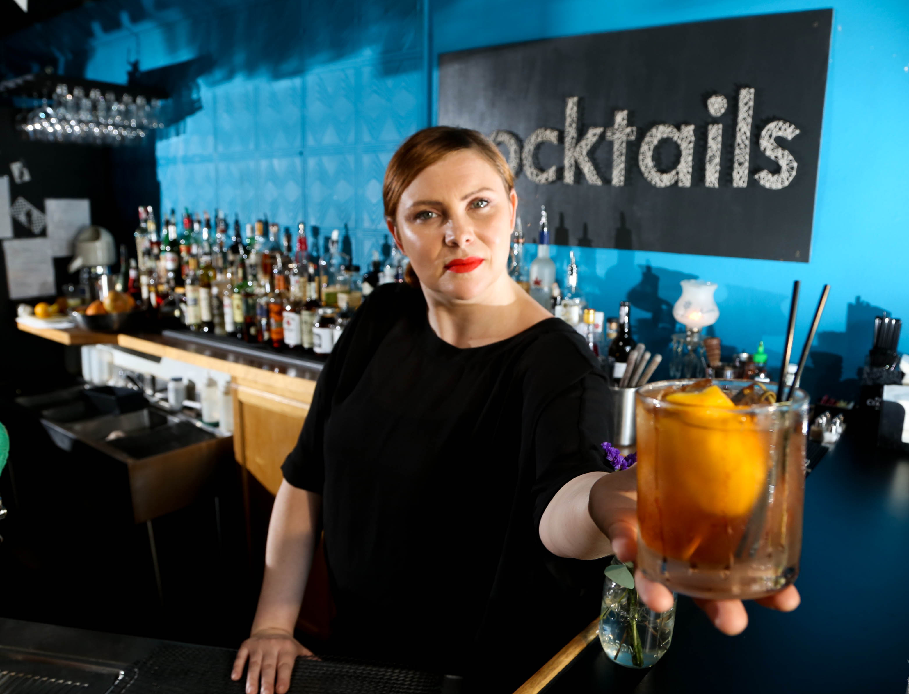 Lily's Bistro's General Manager Emily Mendenhall with "The Whistler" Summer Manhattan made with Bulleit Bourbon, Sweet White Vermouth, Amaretto, Bitters, Squeeze of Fresh Orange, Luxardo Cherry Syrup and Luxardo Cherry garnish. JIM WITMER/STAFF