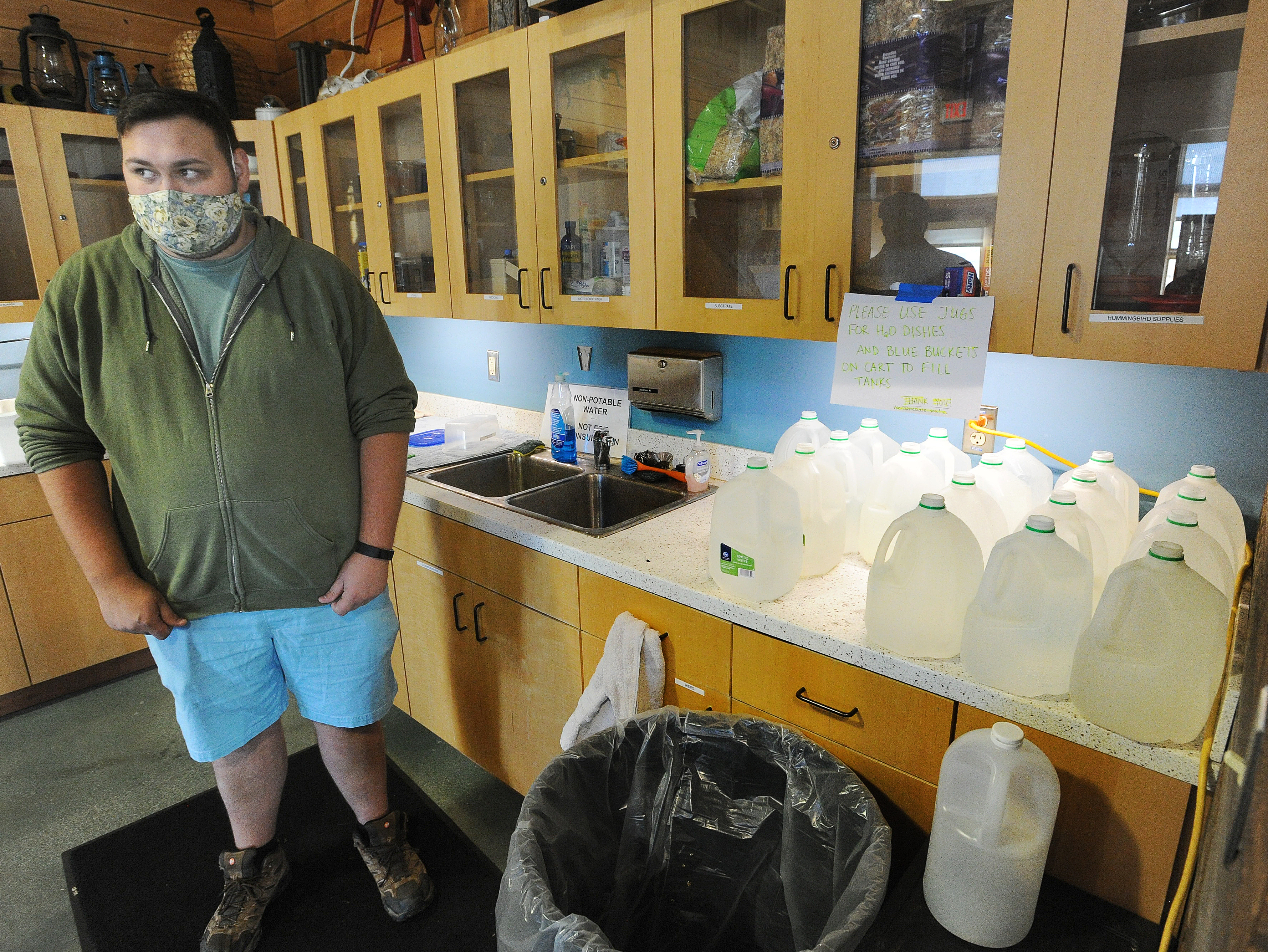 Sean Mormino, environmental education and animal care coordinator at the Aullwood Audubon Farm Discovery Center, stands near jugs the staff uses to transport water for animals after PFAS was discovered in the facility's drinking water system. MARSHALL GORBY\STAFF