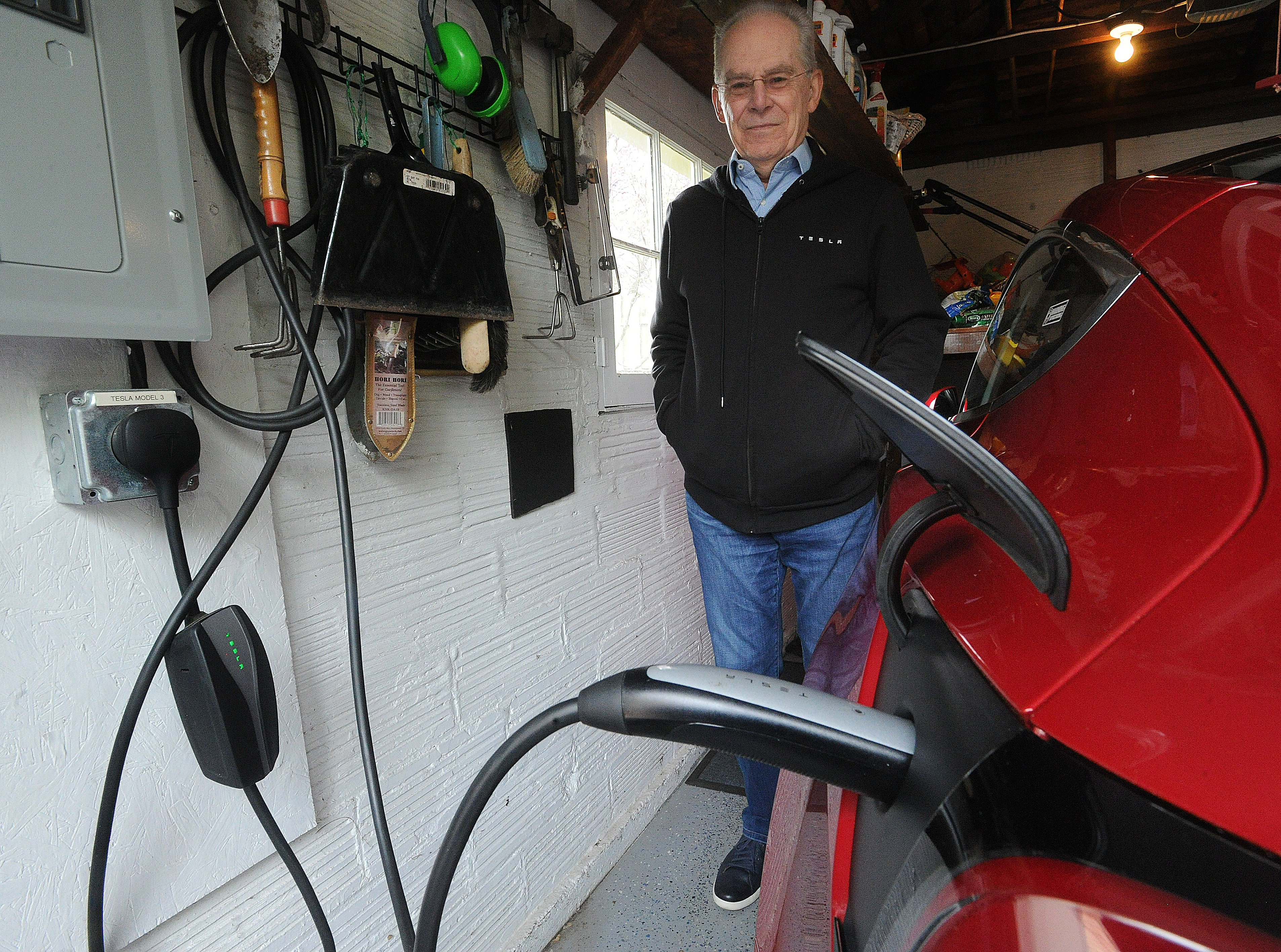 Tim Benford, Chapter President of Drive Electric Dayton, charges his electric car at his home in Oakwood. MARSHALL GORBY\STAFF