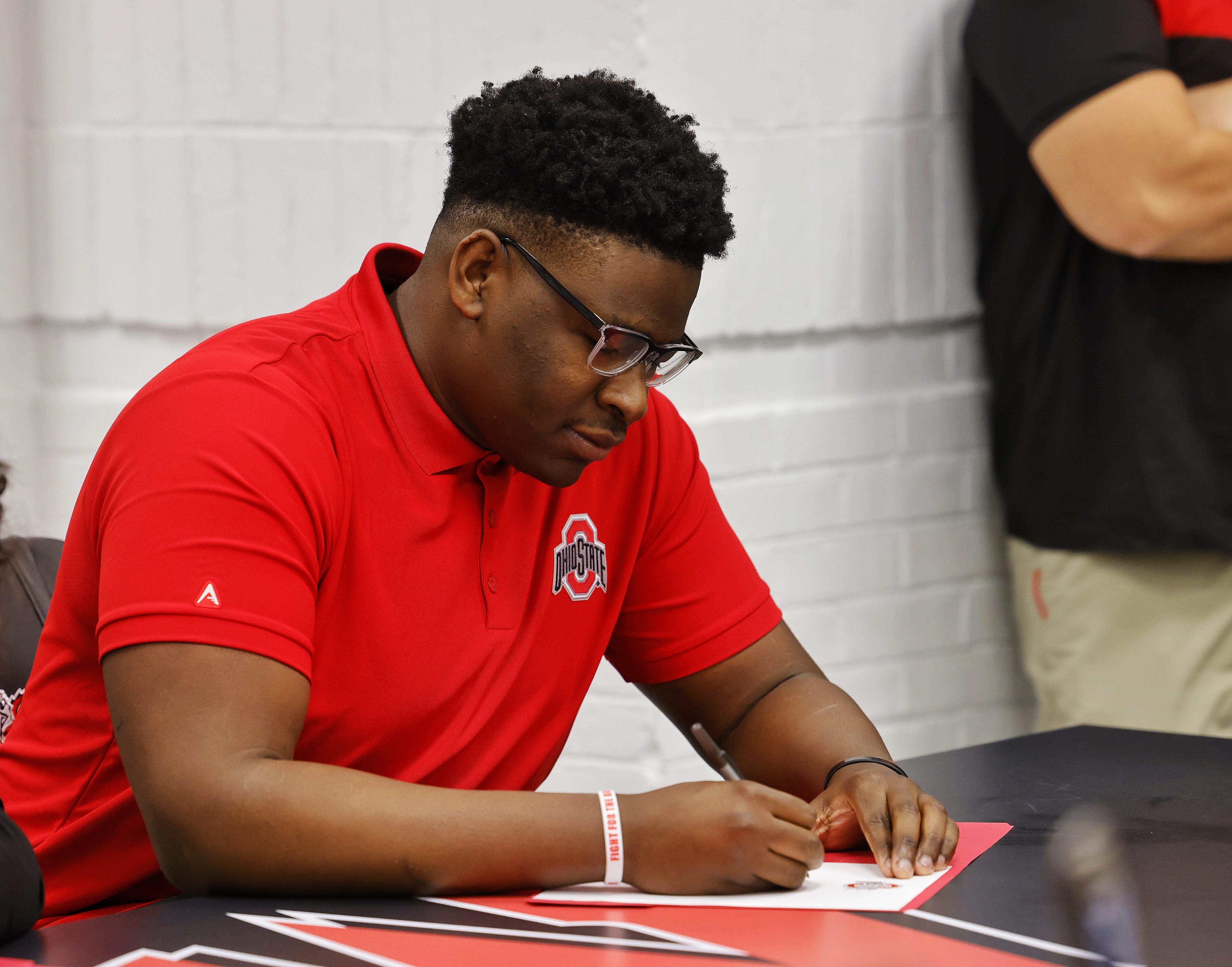 Lakota West's Tegra Tshabola sits during a national letter of intent college football signing ceremony Wednesday, Dec. 15, 2021 at Lakota West High School. Tshabola is signing with The Ohio State University. NICK GRAHAM / STAFF