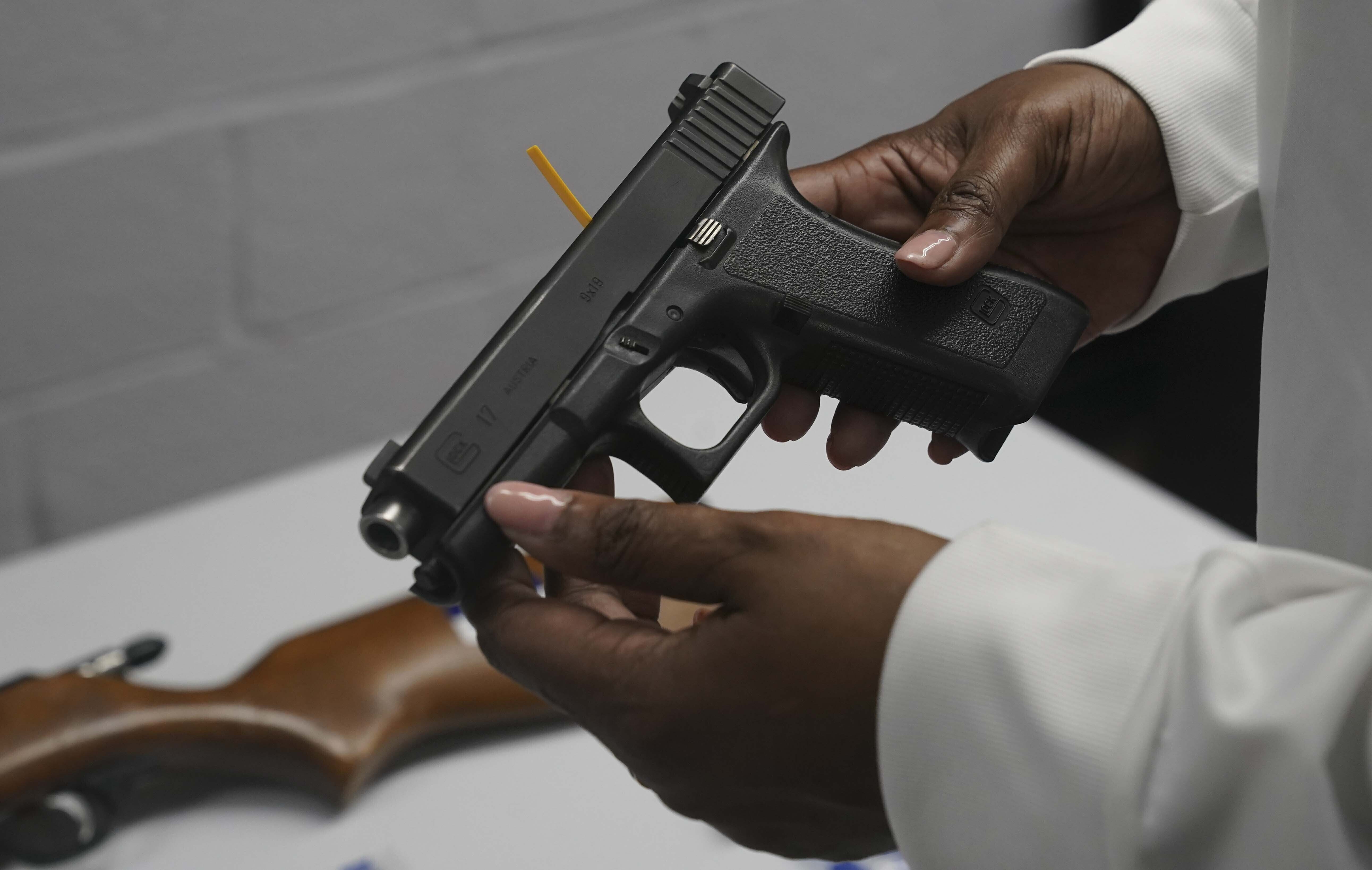 FILE - In this May 22, 2021, file photo a handgun from a collection of illegal guns is reviewed during a gun buyback event in Brooklyn, N.Y. Gun violence is on the rise across the country and law enforcement agencies are struggling with how to manage the spikes, especially in cities. The federal government has stepped in with strike forces and other measures help to stop the sale of illegal weapons. (AP Photo/Bebeto Matthews, FIle)