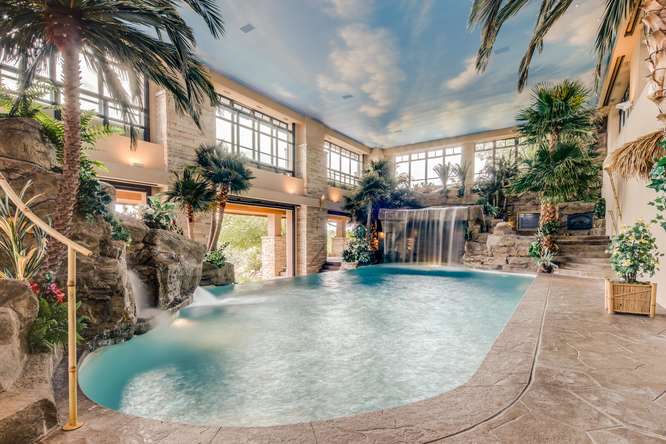 Richard Berry, son of the man who made a fortune on Yellow Pages in Dayton, is selling his nearly $20M mansion in Colorado. The home has seven bedrooms, 12 full baths, four partial baths, 22,864 square feet of living space and more than 74 acres. Built in 2004, at 24503 Chris Drive in Evergreen, Colorado, The home is on the market for $19,999,000. Highlights include a garage larger than the living space that can fit 100 cars, a grotto-style pool modeled after the Playboy mansion, a Star Trek themed movie theater and saltwater aquariums. Berry was a racecar driver in the early 2000s. Photos courtesy of Southeby International Realty