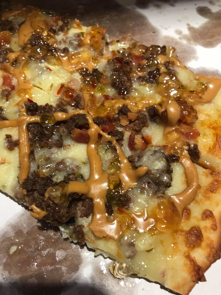 The Tavern Sticky Pizza at The Tavernette Inn. The pizza is topped with hamburger meat, bacon, pepper jack cheese blend, peanut butter, and jalapeño jelly