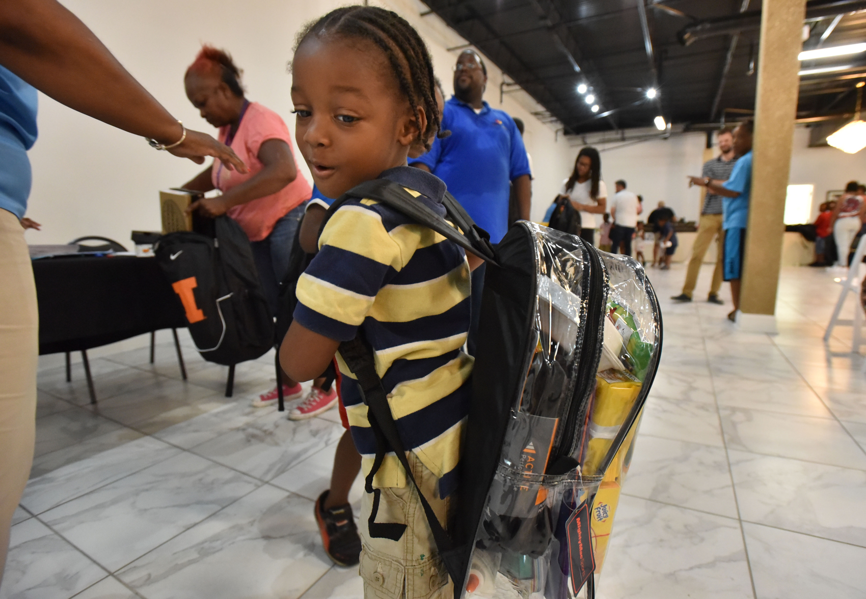 July 15, 2017 Atlanta - Jacques Thomas, 4, turns his head to check his school supplies inside a clear backpack during No Bare Soles Annual Shoe Distribution at Caring For OthersÛª headquarters on Saturday, July 15, 2017. Atlanta-based human services agency Caring For Others hosted annual No Bare Soles Shoes Distribution at their headquarters. More than 250 pairs of brand new shoes were given to local children. School supplies and book bags were also distributed during the event. For the first time, this event took place during summer, making it the perfect opportunity for local kids to get a free pair of brand new back-to-school shoes. HYOSUB SHIN / HSHIN@AJC.COM