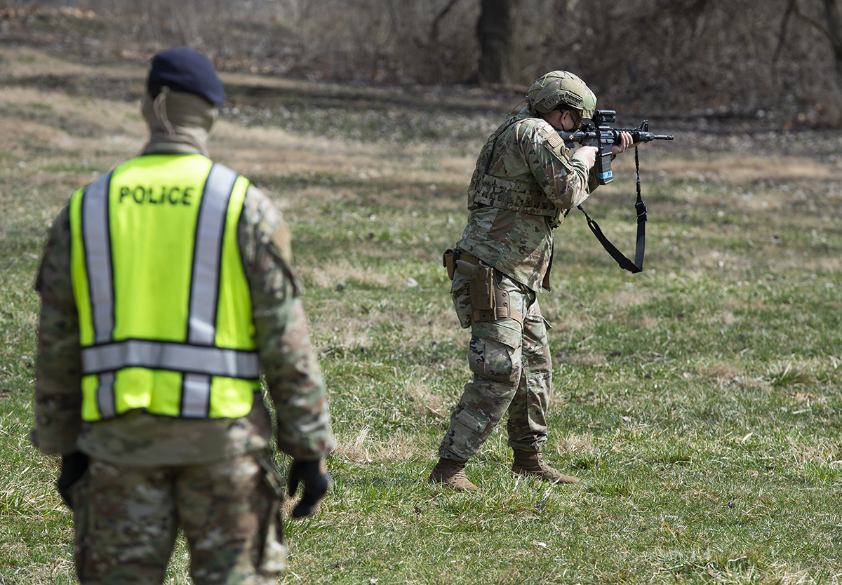 A member of the 88th Security Forces Squadron fires a Simunition round at a fixed target with an M4 carbine rifle as Staff Sgt. Sherman Gramby, a unit training instructor, observes during sustainment training March 17 at Wright-Patterson Air Force Base. U.S. AIR FORCE PHOTO/WESLEY FARNSWORTH
