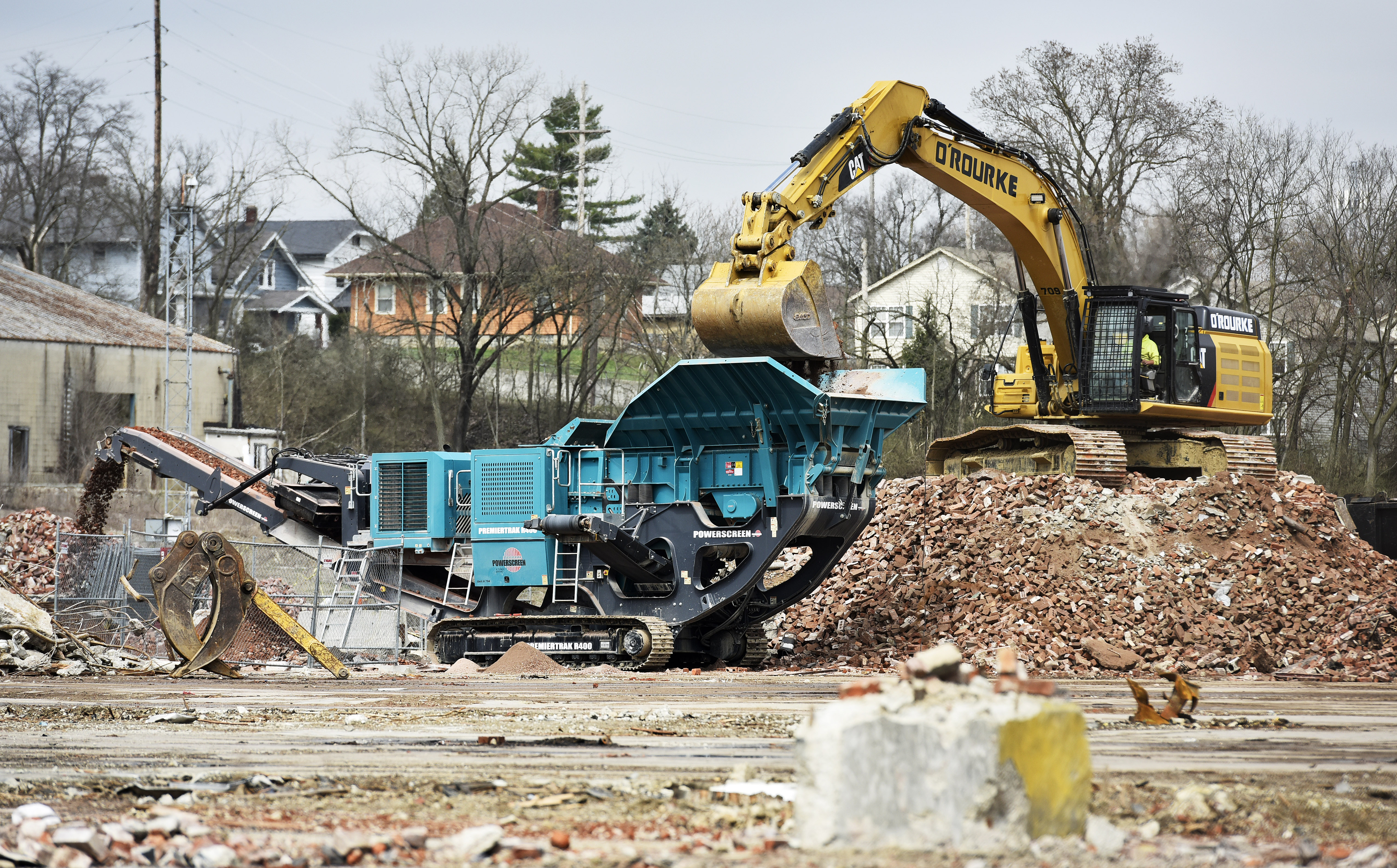 Crews load piles of bricks a machine to pulverize bricks at the former Champion Mill and future Spooky Nook Sports location on B Street Friday, April 5 in Hamilton. NICK GRAHAM/STAFF