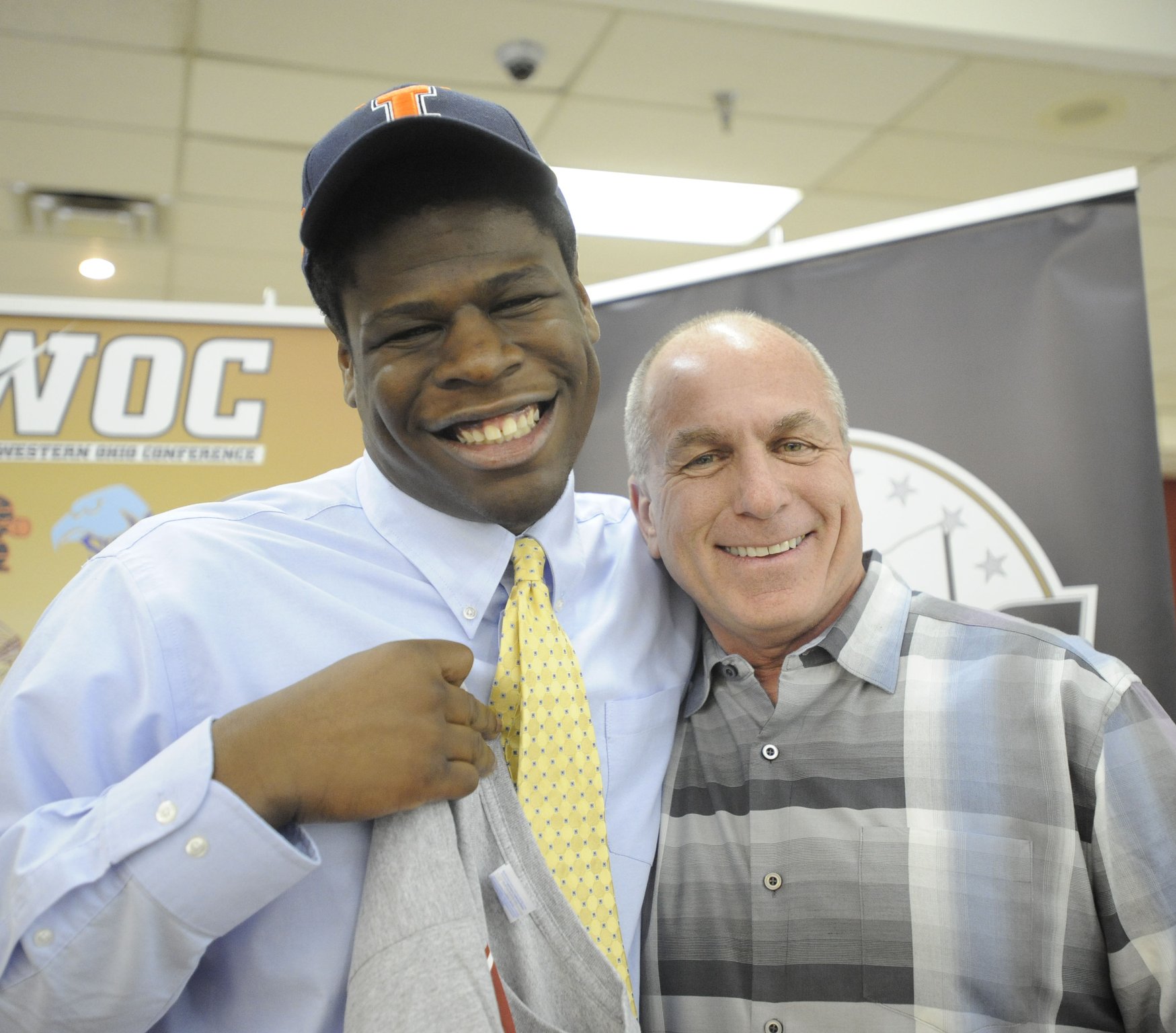 Otito Odenigbo of Centerville High School (left) has the upper hand on former Elks head coach Ron Ullery during a Greater Western Ohio Conference signing ceremony at the Huber Heights Athletic Foundation Center last February. Odenigbo signed with the University of Illinois. MARC PENDLETON / STAFF