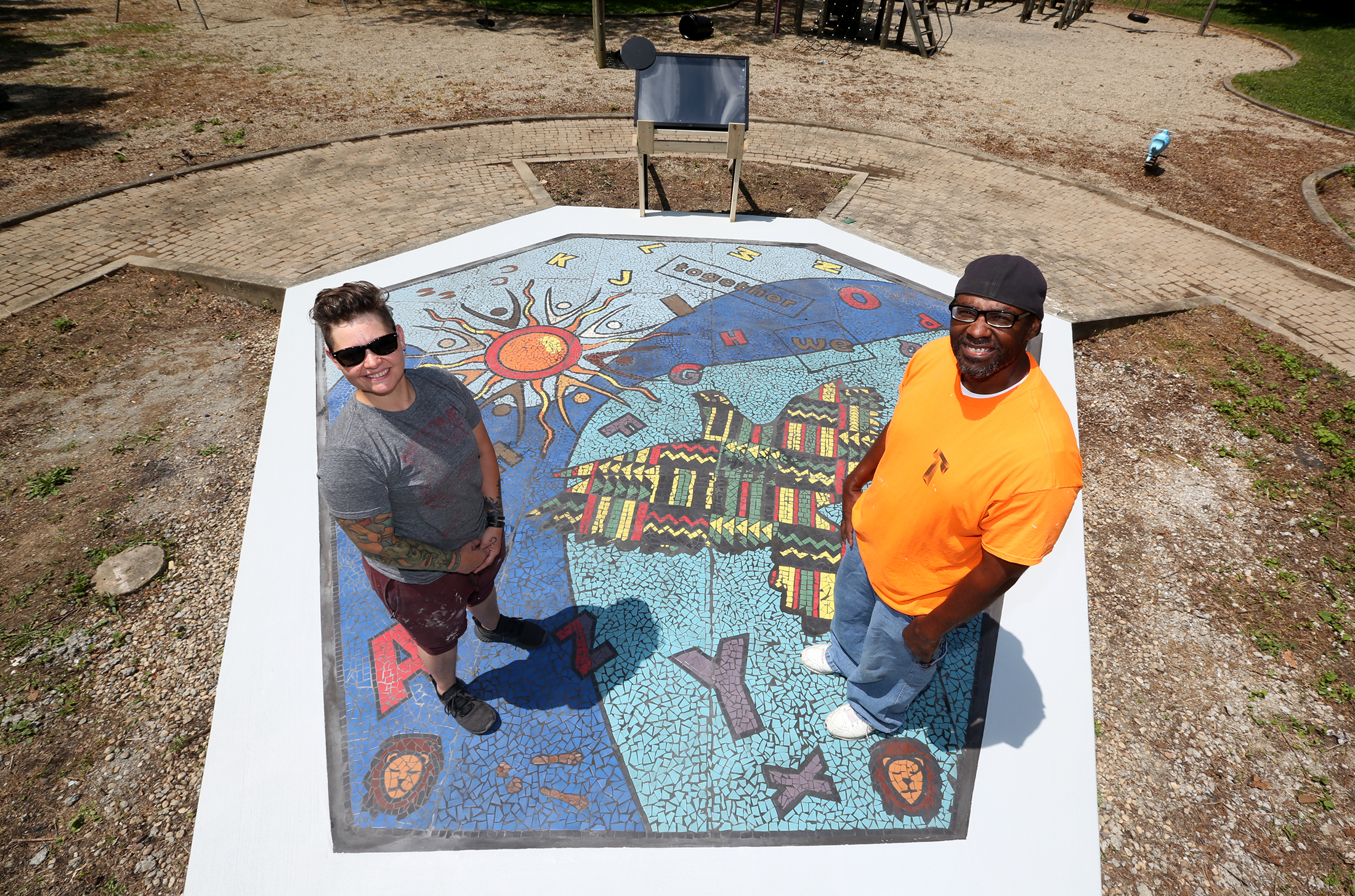 "Together We Rise," designed by Jes McMillan, founder of the Mosaic Institute of Dayton and Charles Boogie Sweeney, a Dayton artist, is a new large-scale play area and work of art in West Dayton. The in-ground mosaic is a play station designed with interactive games, alphabet letters and raised areas for crayon rubbings. It is located in a playground at the intersection of Harvard Boulevard and Burroughs Drive on the Omega CDC Harvard Campus. LISA POWELL / STAFF