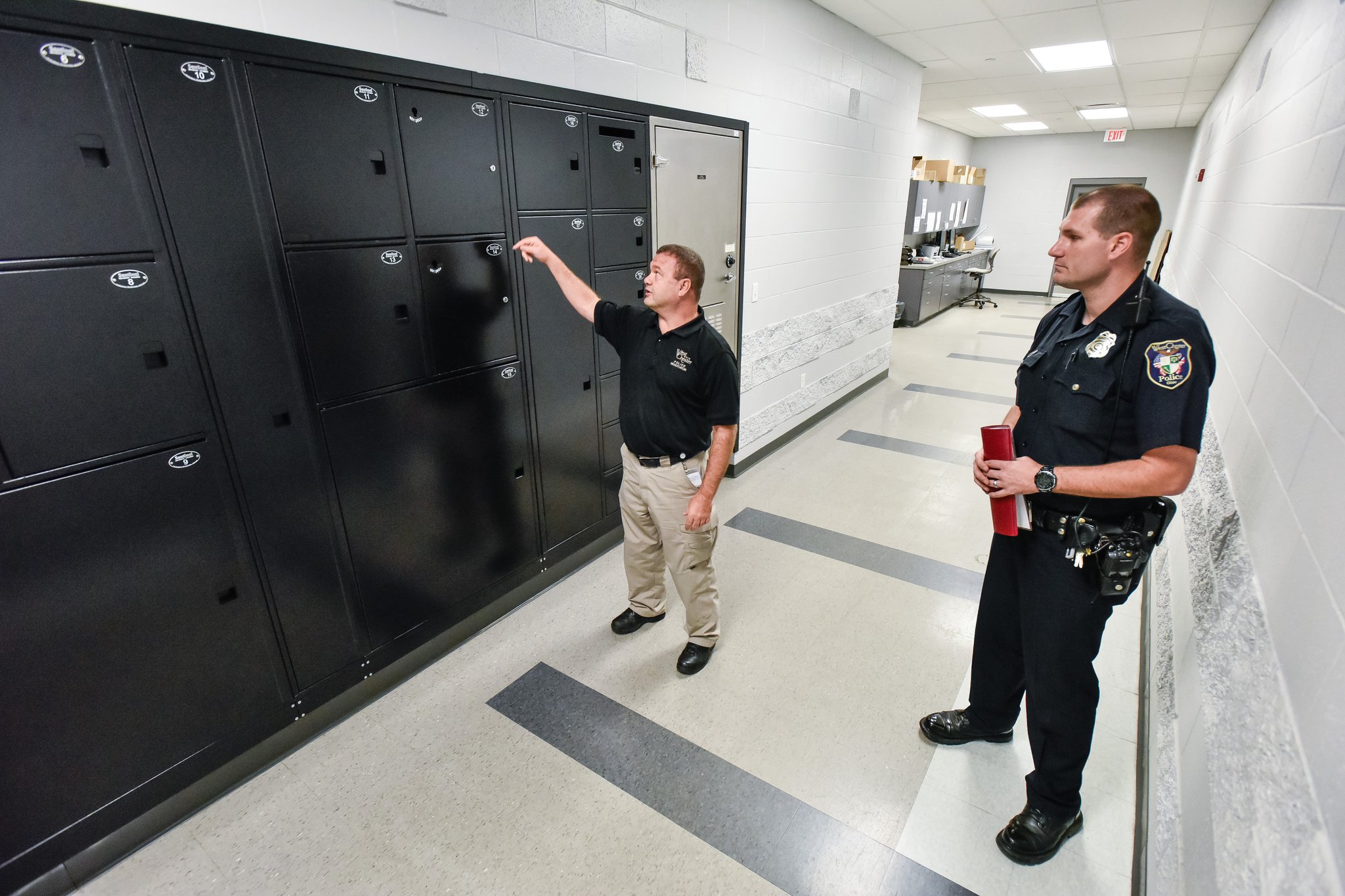 West Chester Police officers Ernie Malott, left, and Joshua Cupp show the lockers used to transfer evidence into the evidence room at the West Chester Police Department.