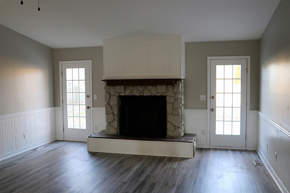 At the entrance of the house is the combined family room and dining room. A wood-burning fireplace has received a façade update with stone surround and a raised hearth and wood-beam mantel. CONTRIBUTED PHOTO BY KATHY TYLER