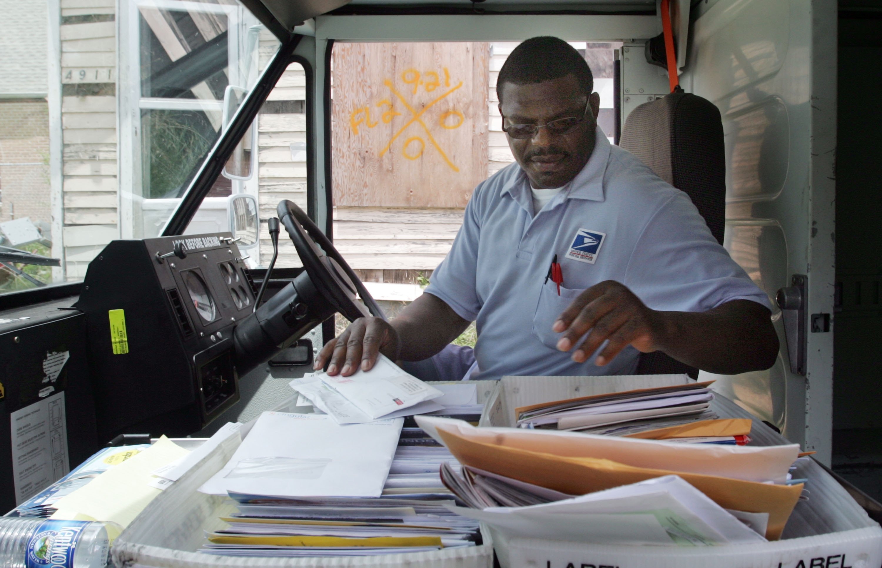 NEW ORLEANS - JULY 18: United States Postal Service letter carrier Wayne Treaudo delivers mail to a house marked by rescue workers in the Lower Ninth Ward July 18, 2006 in New Orleans, Louisiana. Yesterday was the first day mail service returned to residents of the Lower Ninth since Hurricane Katrina struck nearly eleven months ago. (Photo by Mario Tama/Getty Images)