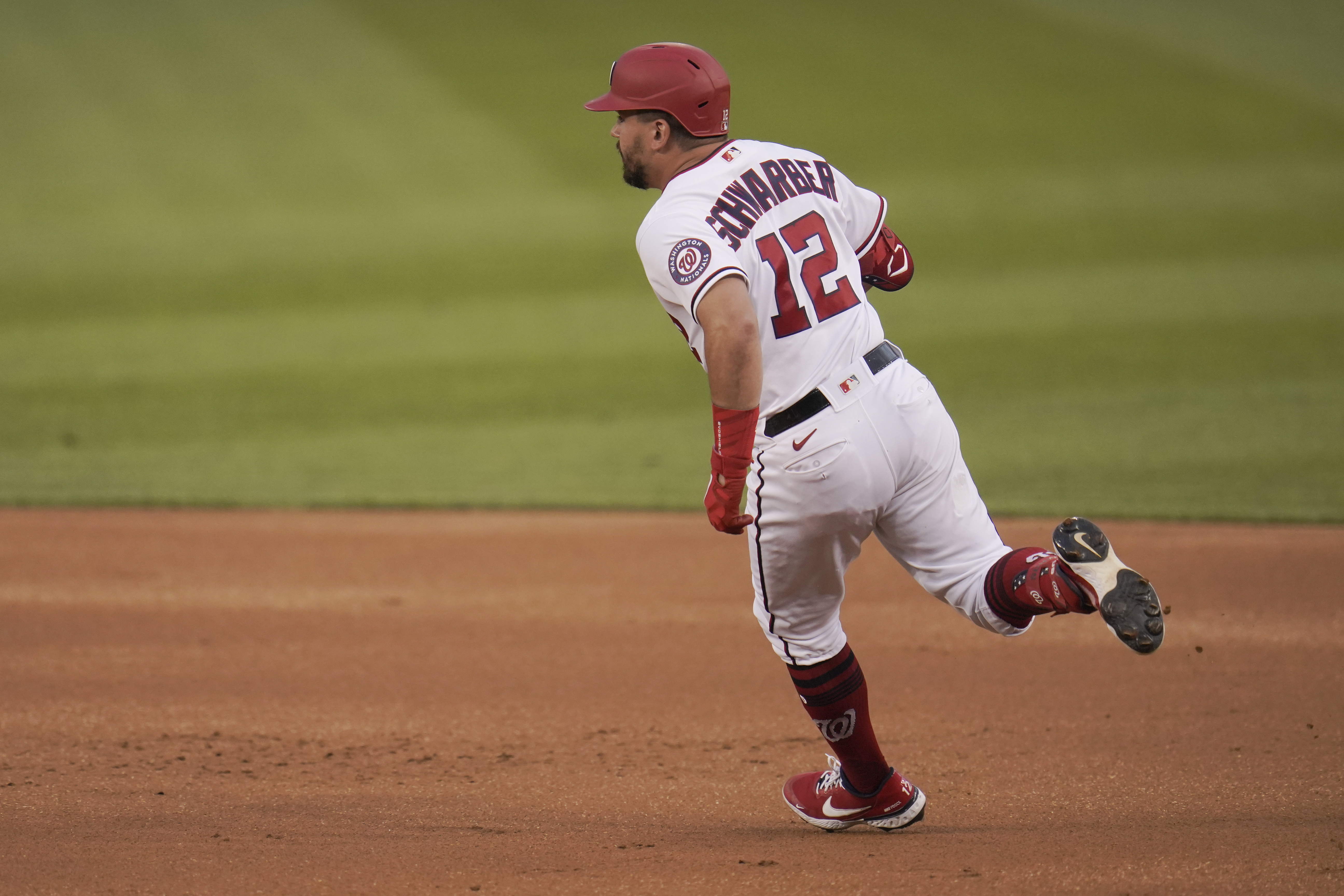 Washington Nationals' Kyle Schwarber rounds first base while hitting a double off Los Angeles Dodgers starting pitcher Victor Gonzalez during the first inning of a baseball game, Thursday, July 1, 2021, in Washington. (AP Photo/Julio Cortez)