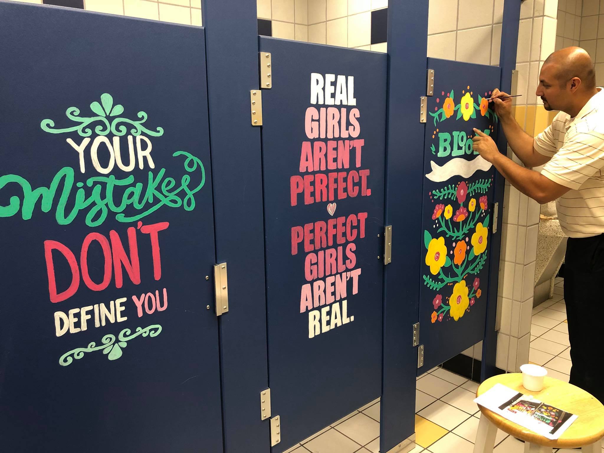 Principal adds finishing touches to one of the bathroom stalls.