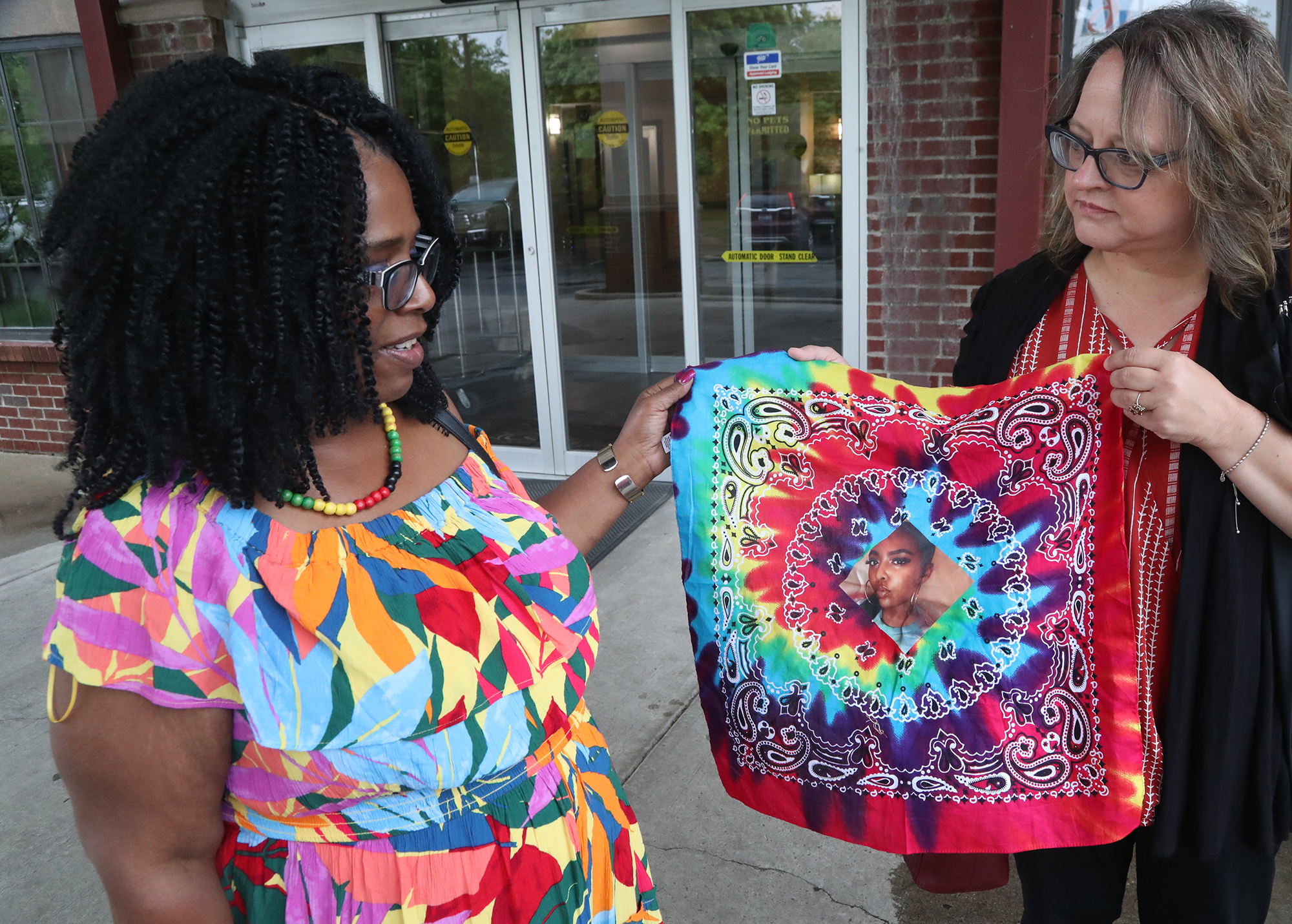 Springfield resident, Stacy Cameron, left, and her friend, Amy Willmann, hold up a bandana with Stacy's daughter, Shauna Cameron, on it Wednesday, May 18, 2022. Shauna was shot and killed while riding in a car along U.S. 35 in Riverside on May 8, 2022. BILL LACKEY/STAFF