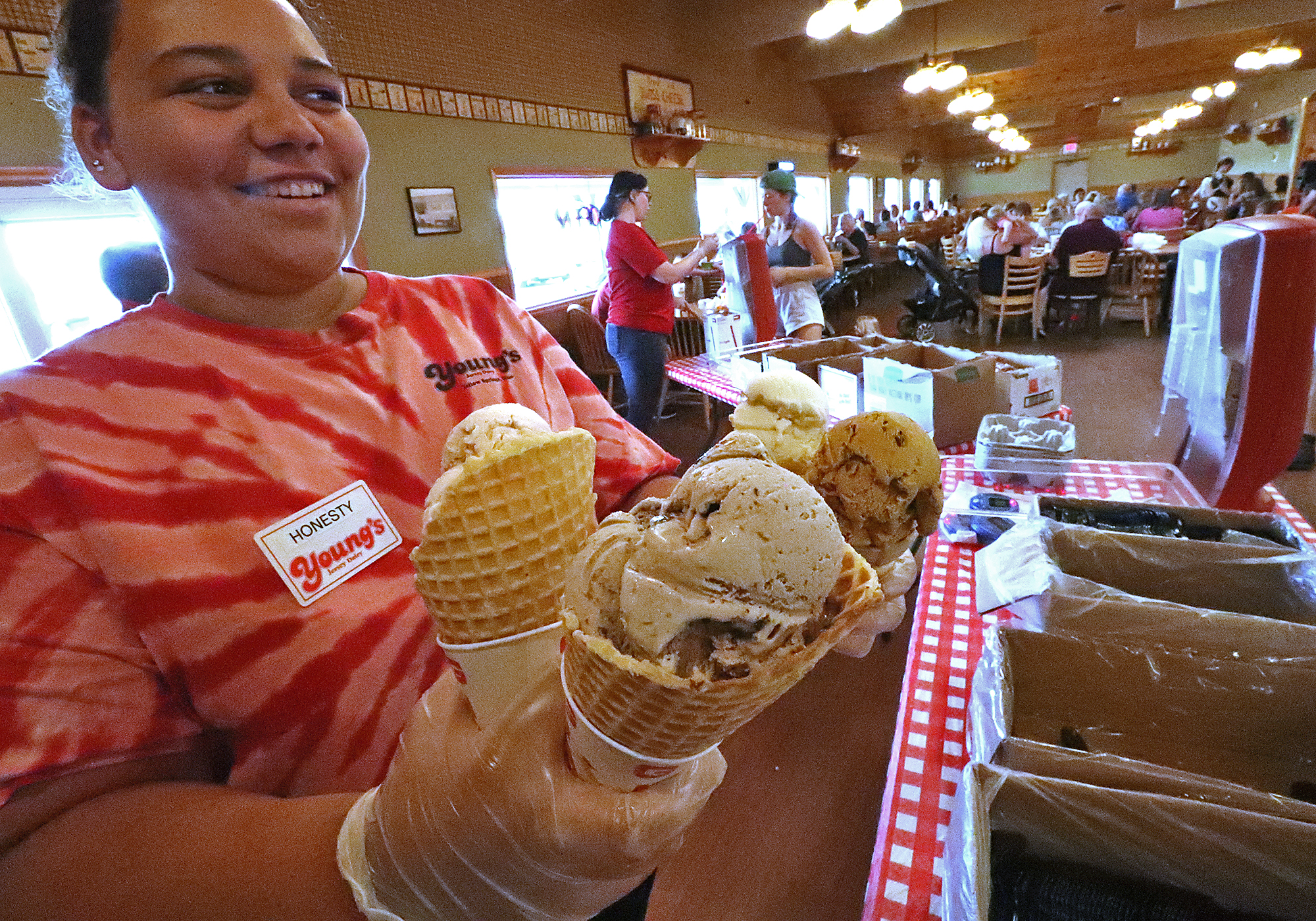 Honesty Spradlin, an employee a Young's Jersey Dairy, waits for a customer to pick up the four ice cream comes Thursday at the Dairy. BILL LACKEY/STAFF