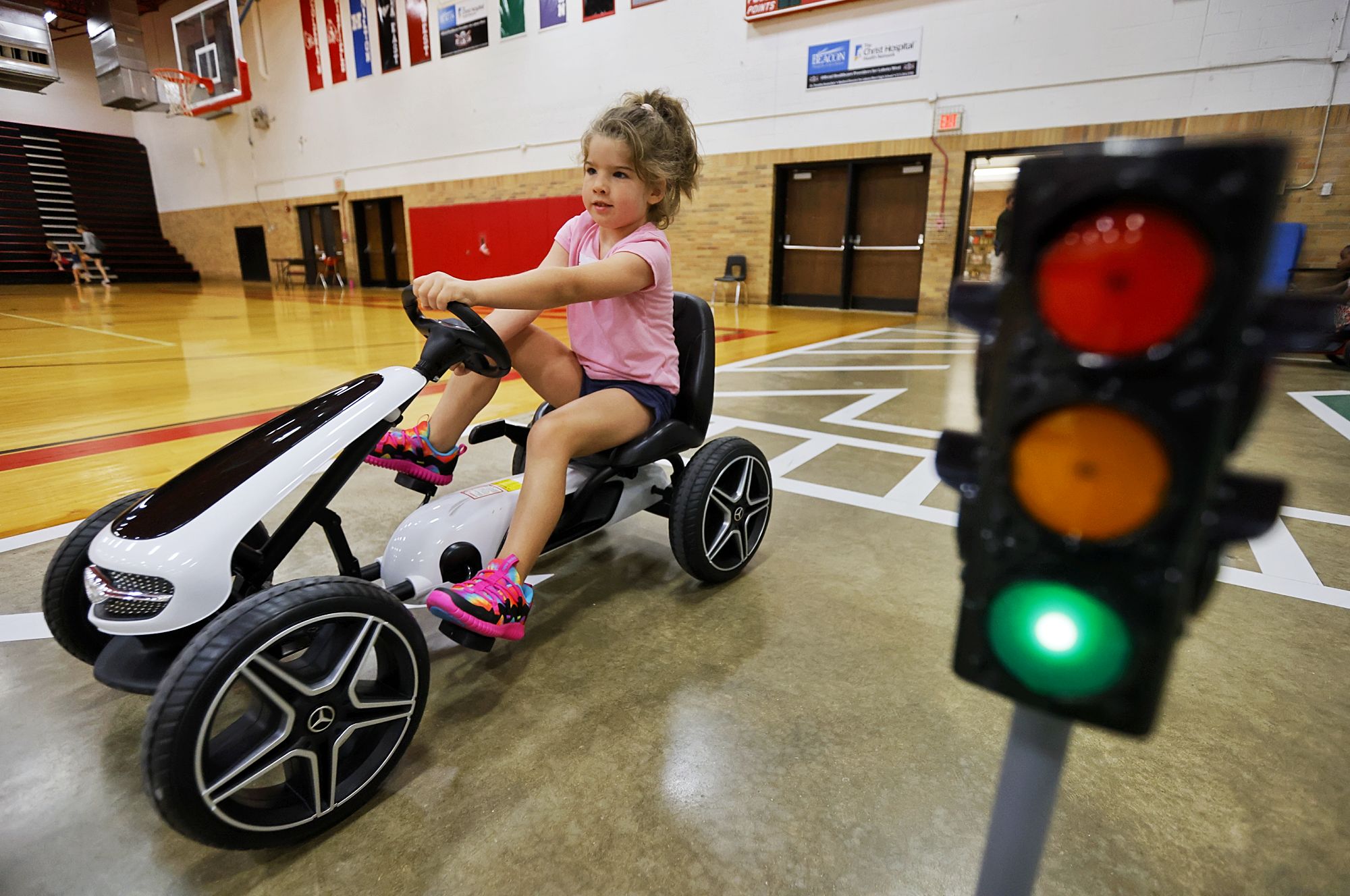 Evelyn Sweemer, 5, drives a pedal car during Lakota Safety Village. Lakota schools, West Chester Police Department, Butler County Sheriff's Office and other have partnered for Lakota Safety Village to teach young children going into kindergarten school etiquette, bus and car safety, fire safety and more at Lakota Freshman School in West Chester Township. NICK GRAHAM/STAFF