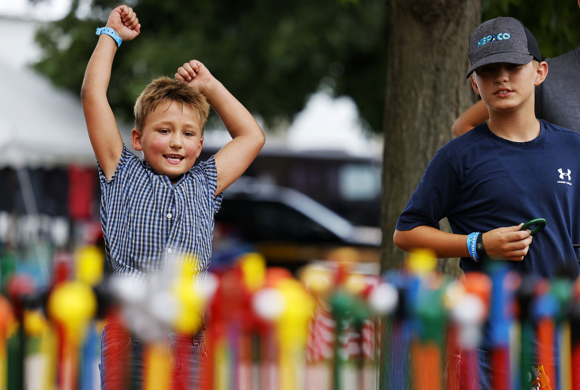 Garrett Van Gorden,7, left, with Jake Van Gorden, right, cheers after winning a cane at the Dearwester Canes booth at Butler County Fair Monday, July 25, 2022 in Hamilton. Dearwester Canes has been coming to the Butler County Fair for 130 years. NICK GRAHAM/STAFF