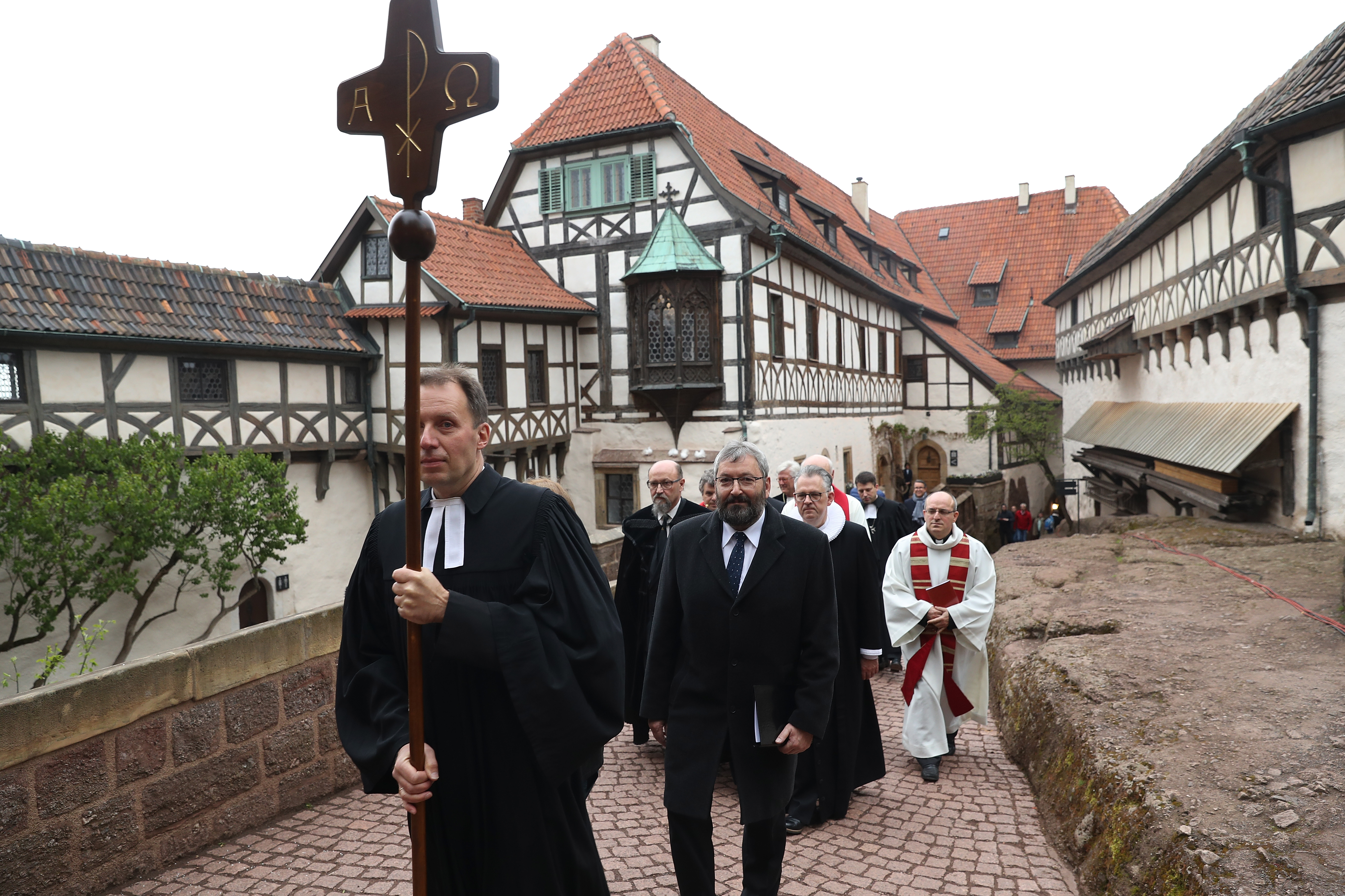 EISENACH, GERMANY - MAY 04: Protestant clergy, led by pastor Christian Mueller, walk in a procession with a cross to an open-air church service at Wartburg Castle to commemorate the May 4, 1521, arrival of Martin Luther on May 4, 2017 in Eisenach, Germany. Luther, who is known for his 95 theses of 1517 that set the Reformation into motion, lived at Wartburg Castle under protection following his excommunication and translated the Bible there into German. Germany is celebrating the 500th anniversary of the Reformation this year with events throughout the year. The Reformation led to the creation of Protestant denominations all over the globe. (Photo by Sean Gallup/Getty Images)