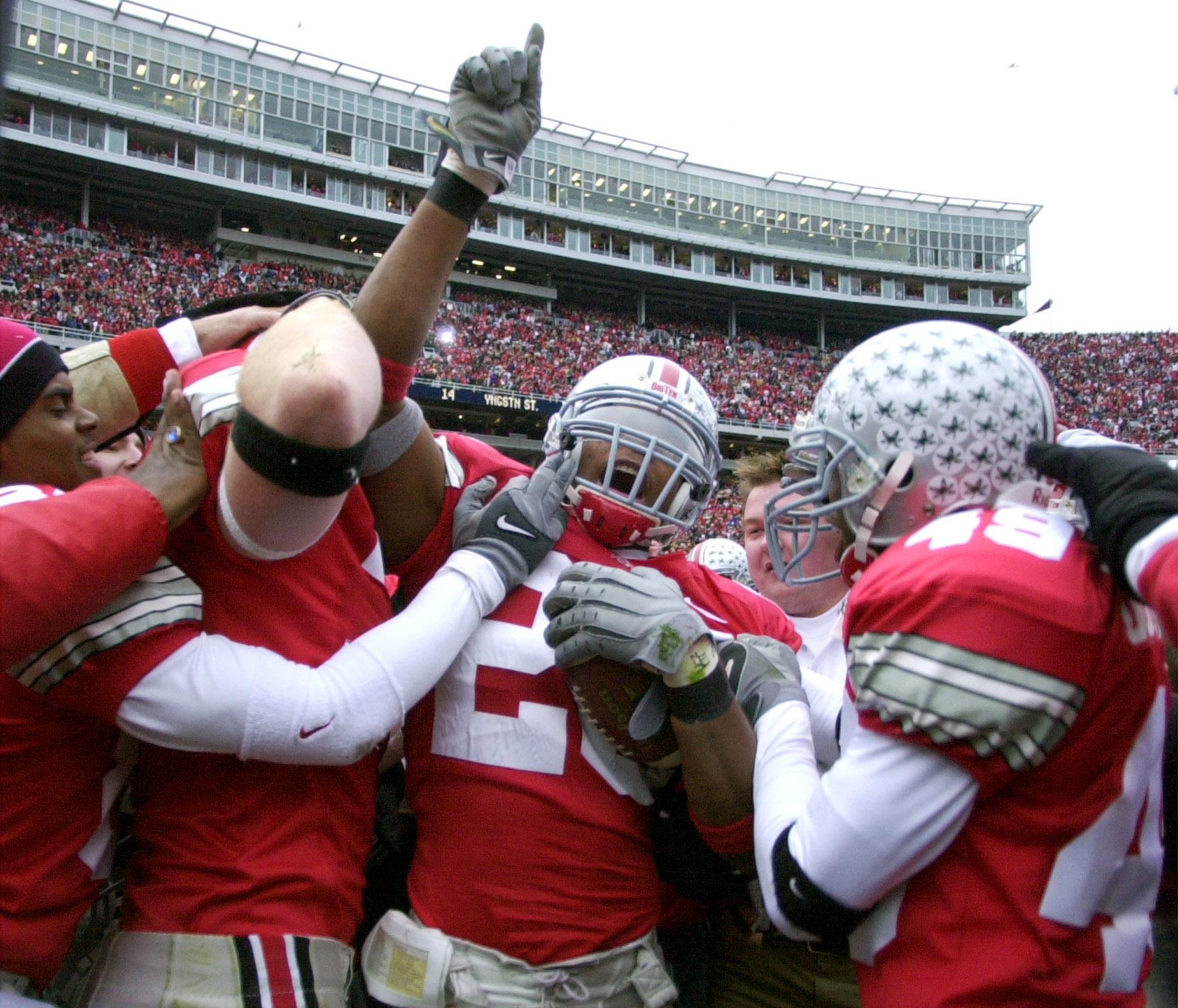 ** FILE ** In this Nov. 23, 2002 file photo, Ohio State free safety Will Allen (26) is mobbed by teammates in Columbus, Ohio after Allen intercepted a pass just short of the goal line on the football game's final play as the Buckeyes held off Michigan 14-9 to complete the regular season and set the table for the breathless bowl game. Celebrating with Allen are John Hollins (84) and E.J. Underwood (49). (AP Photo/Amy Sancetta, File)