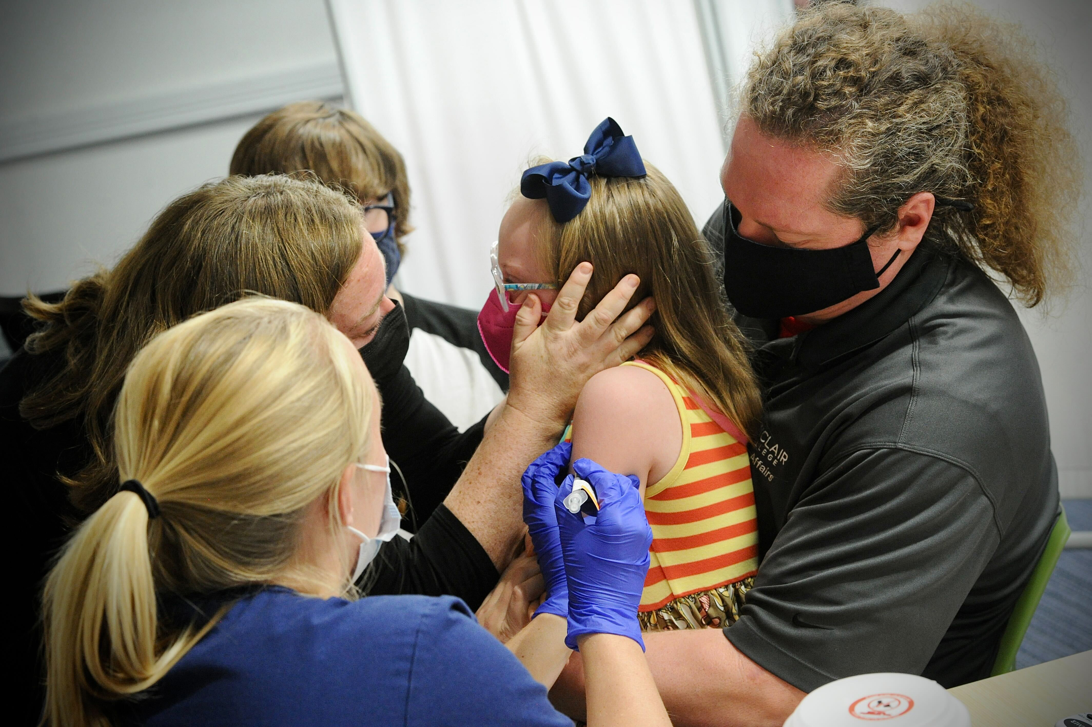 Joy Minor is held by her father Paul while talking with her mother, Jessica as she receives her COVID-19 vaccine at Dayton Children's Monday, Nov. 8, 2021. MARSHALL GORBY\STAFF