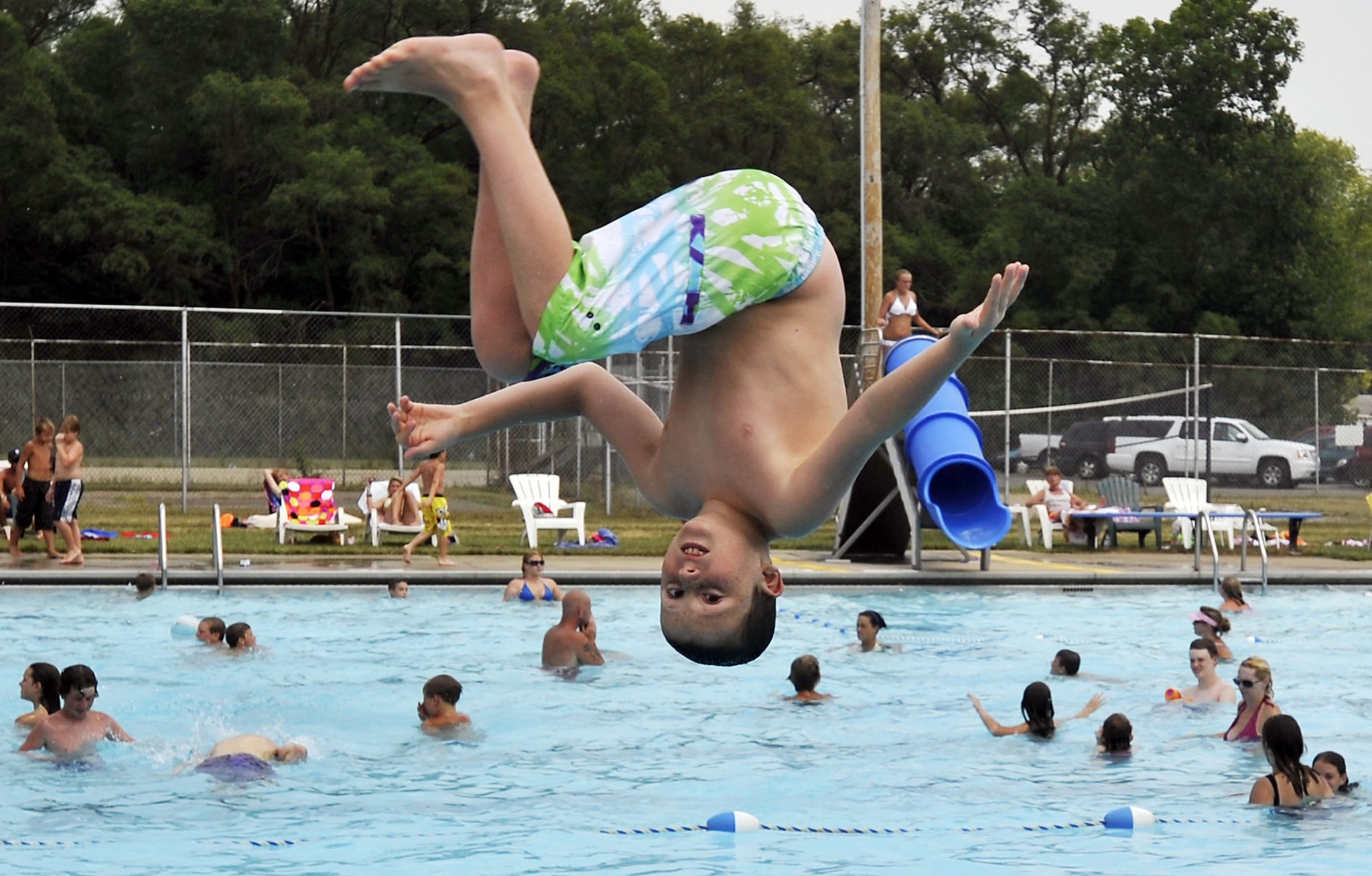 Nash Emberton hangs over the New Carlisle pool as he flips off the diving board during the summer. New Carlisle council members recently voted to keep the city’s public pool open through 2015, but the city manager hopes the council will reconsider because it is losing money annually. Bill Lackey/Staff