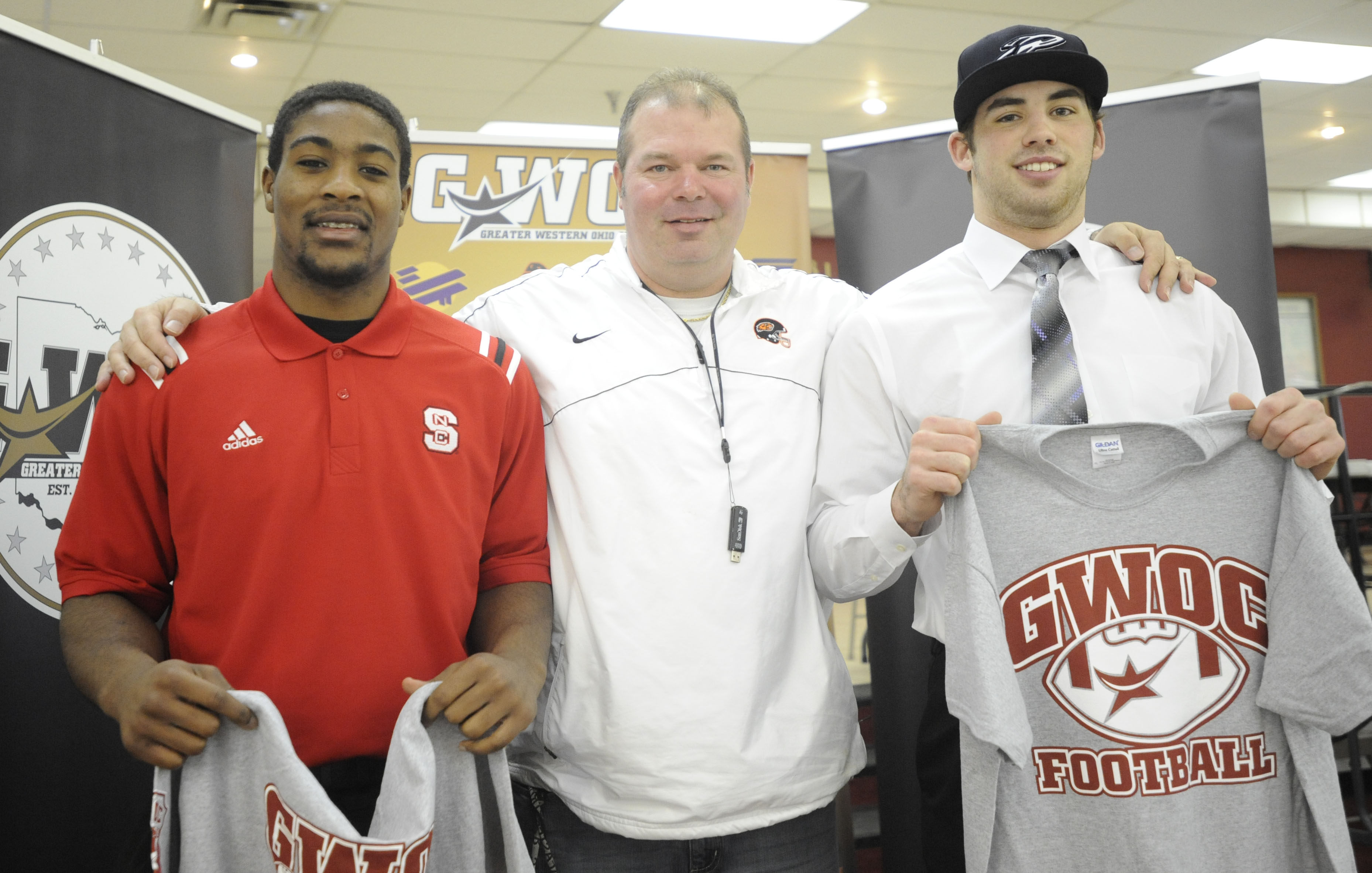 Airius Moore of Beavercreek H.S. (left), Beavers head football coach Scott Clodfelter and Beavercreek's Mike Berry ) were among those at the Greater Western Ohio Conference college football signing ceremony at the Huber Heights Athletic Foundation Center on Friday, Feb. 7, 2014. MARC PENDLETON / STAFF