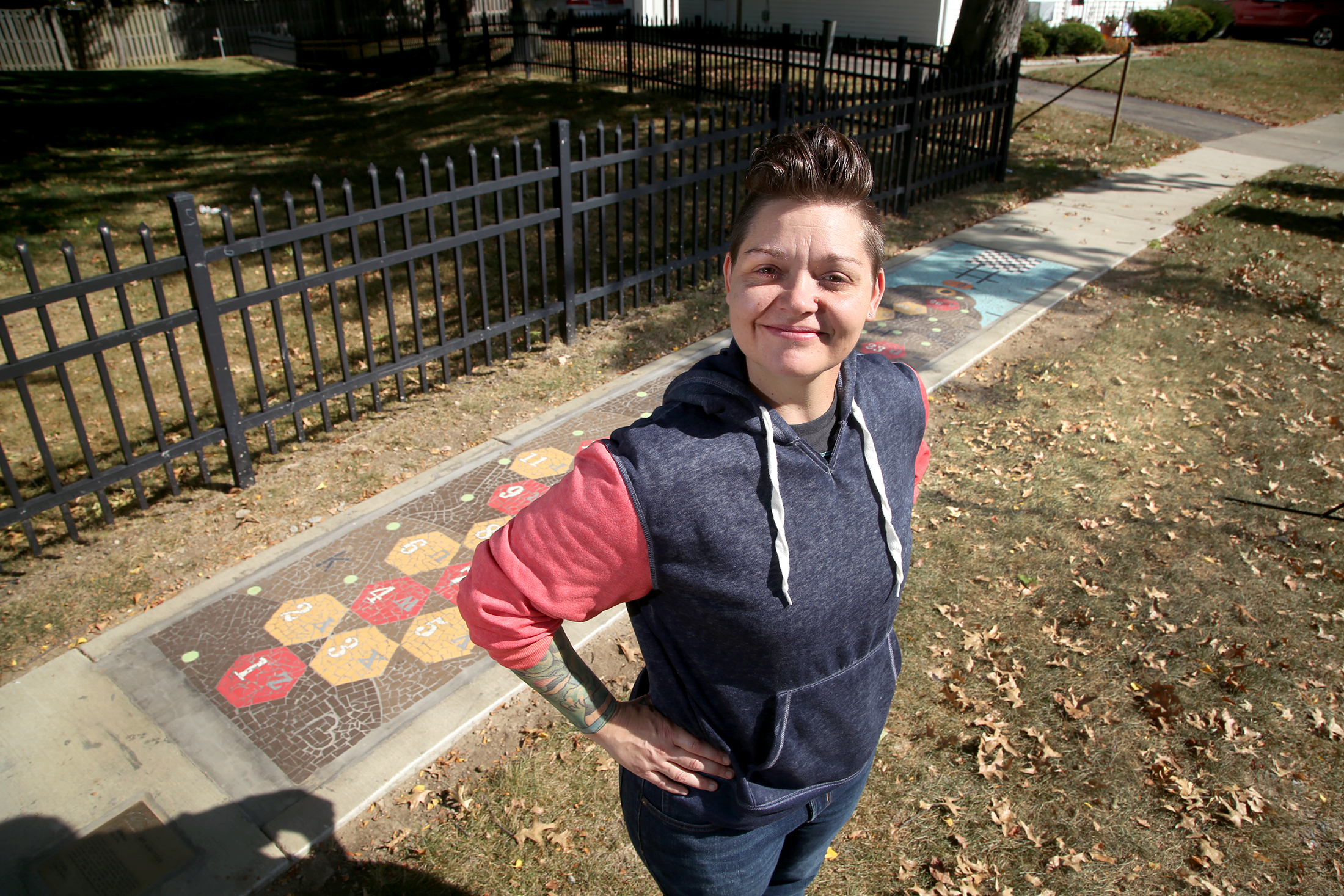 Jes McMillan, founder of The Mosaic Institute of Greater Dayton, spearheaded the creation of "Bee Ambitious," a public artwork that is also a series of interactive games, in Kettering's Haverstick neighborhood. LISA POWELL / STAFF