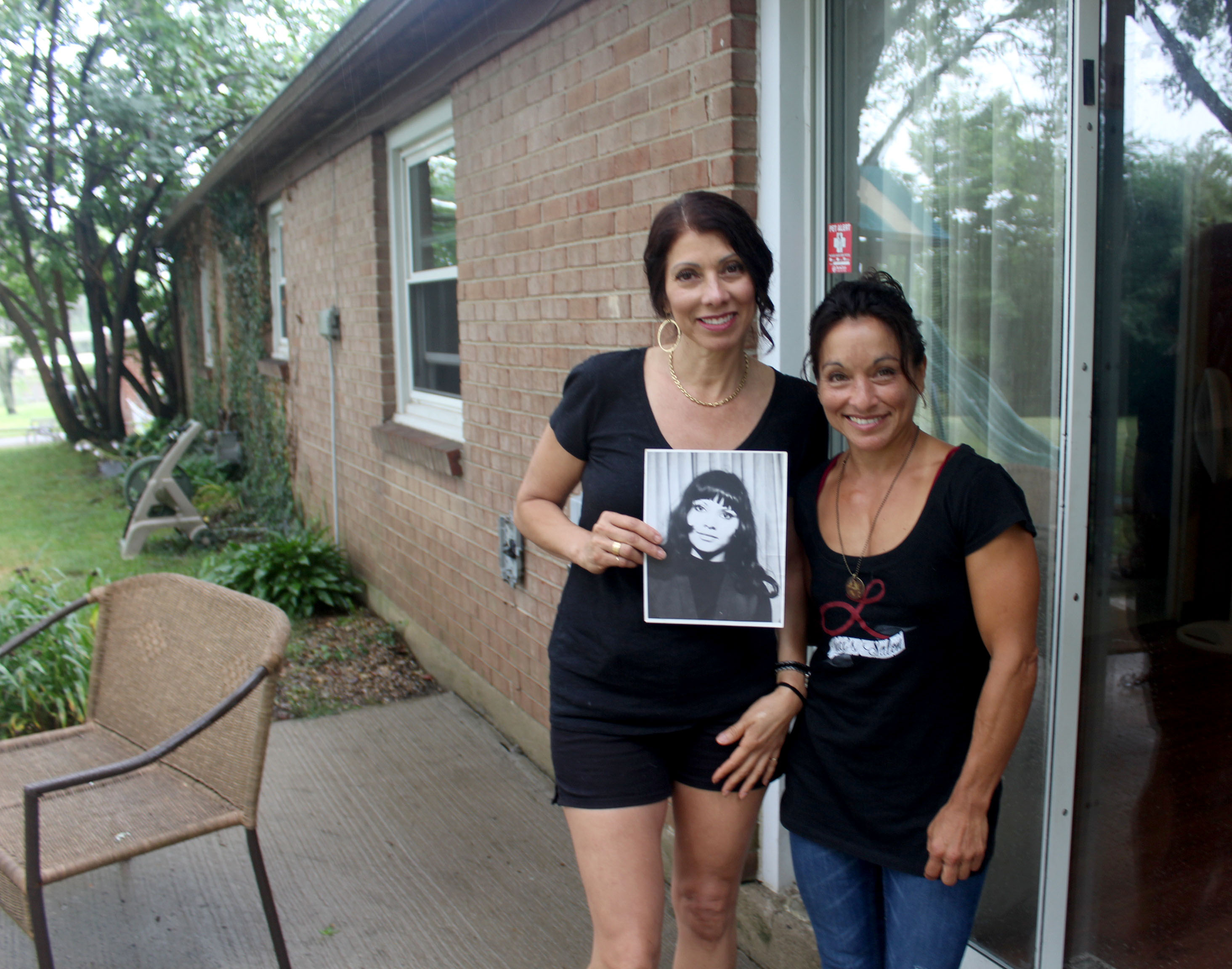 Adopted at birth, Lucianna Seed recently met family members she never knew she had including Centerville's Raquel Rivera-Hill. The sisters hold a photo of their mom Yadira Rivera.
