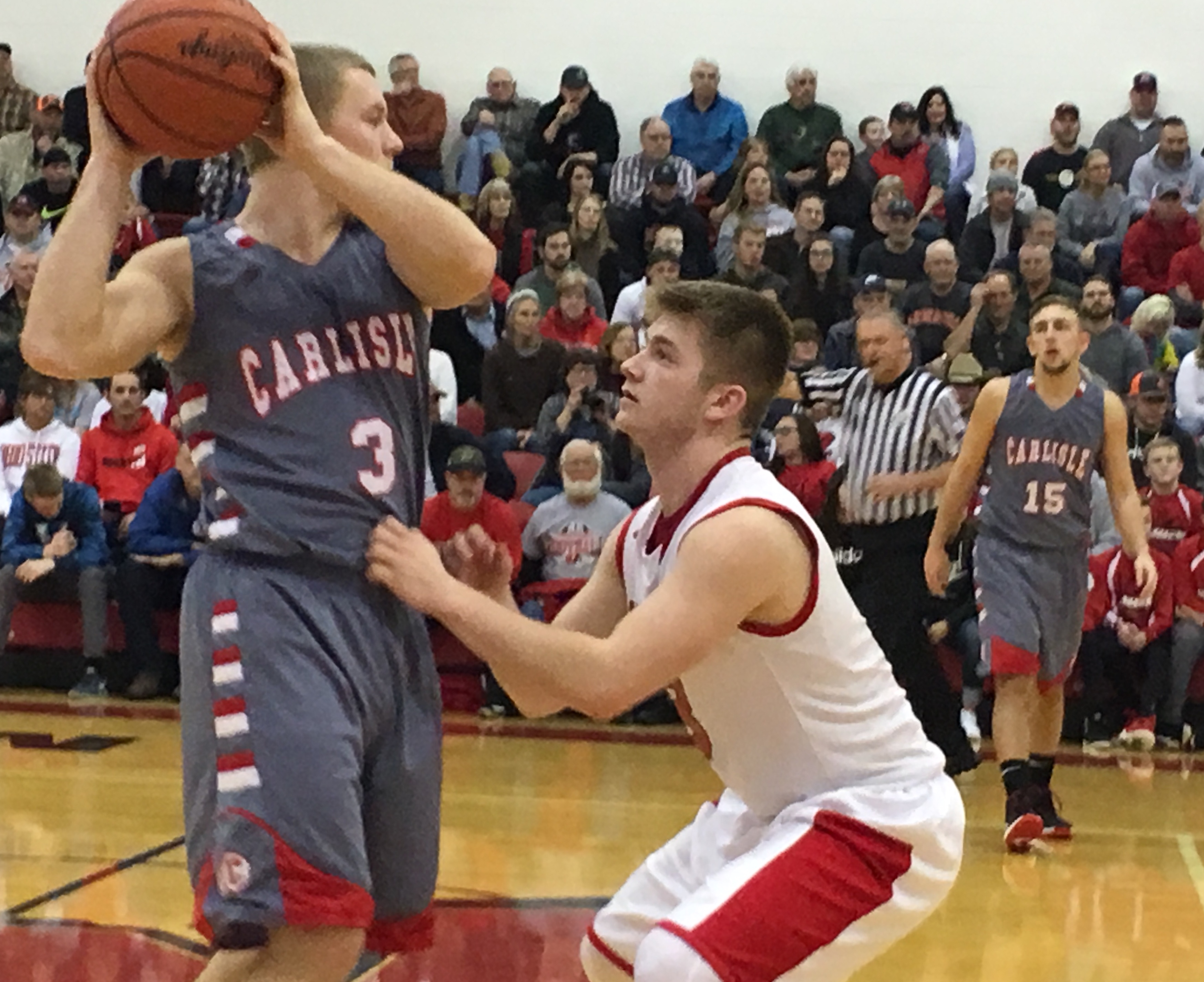 Madison’s Mason Whiteman (right) gets up close and personal with Carlisle’s Jake Moore during Tuesday night’s game in Madison Township. RICK CASSANO/STAFF