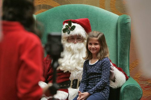 Santa Claus visits with children at the Dayton Mall in this file photo. Children will not be able to sit on Santa's lap this year. JIM NOELKER/STAFF