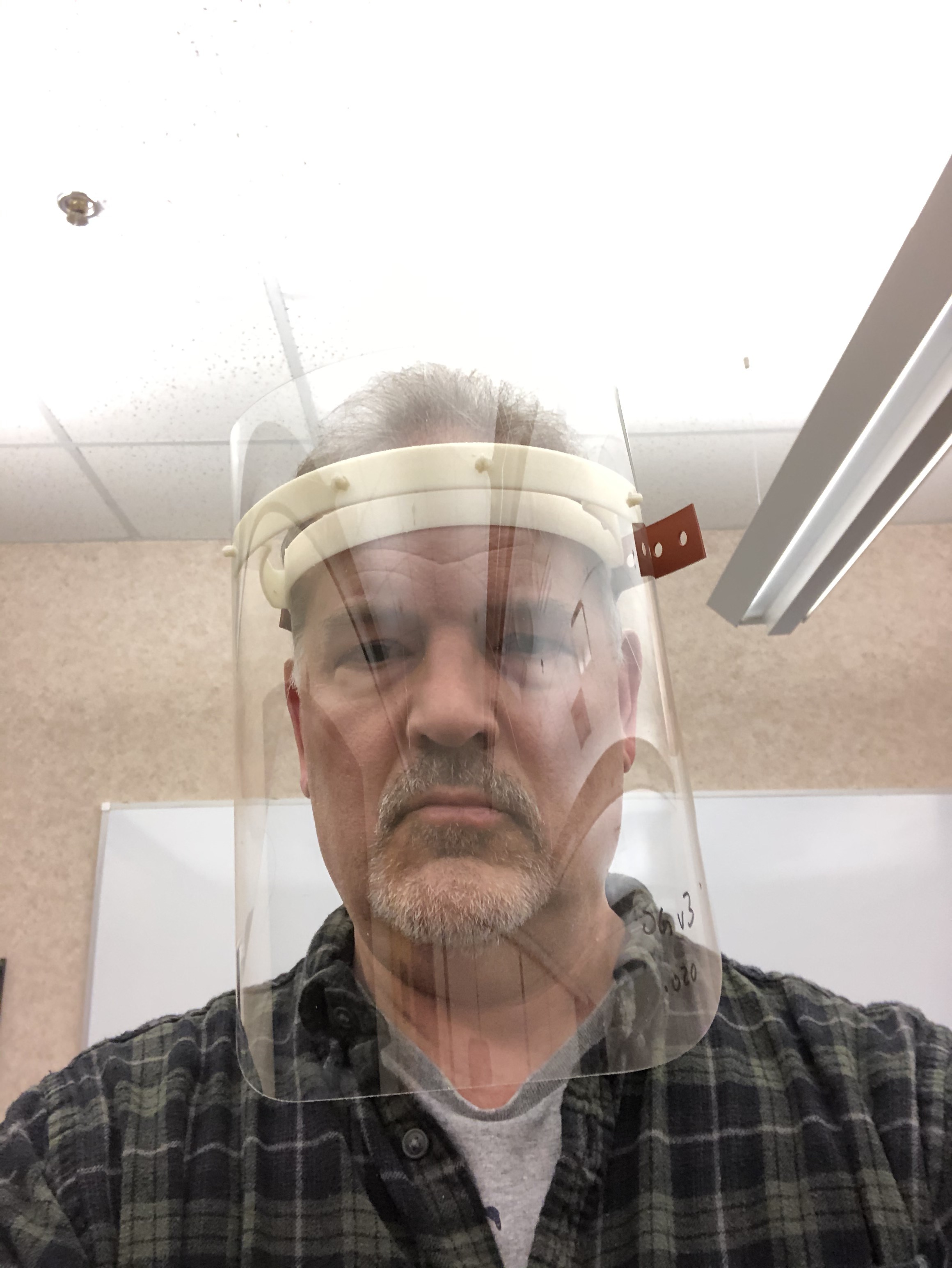 Mike Pintz, with the Magnet MEP manufacturering consultant in Cleveland, demonstrates a prototype face shield that Ohio manufacturers have banded togther to make.