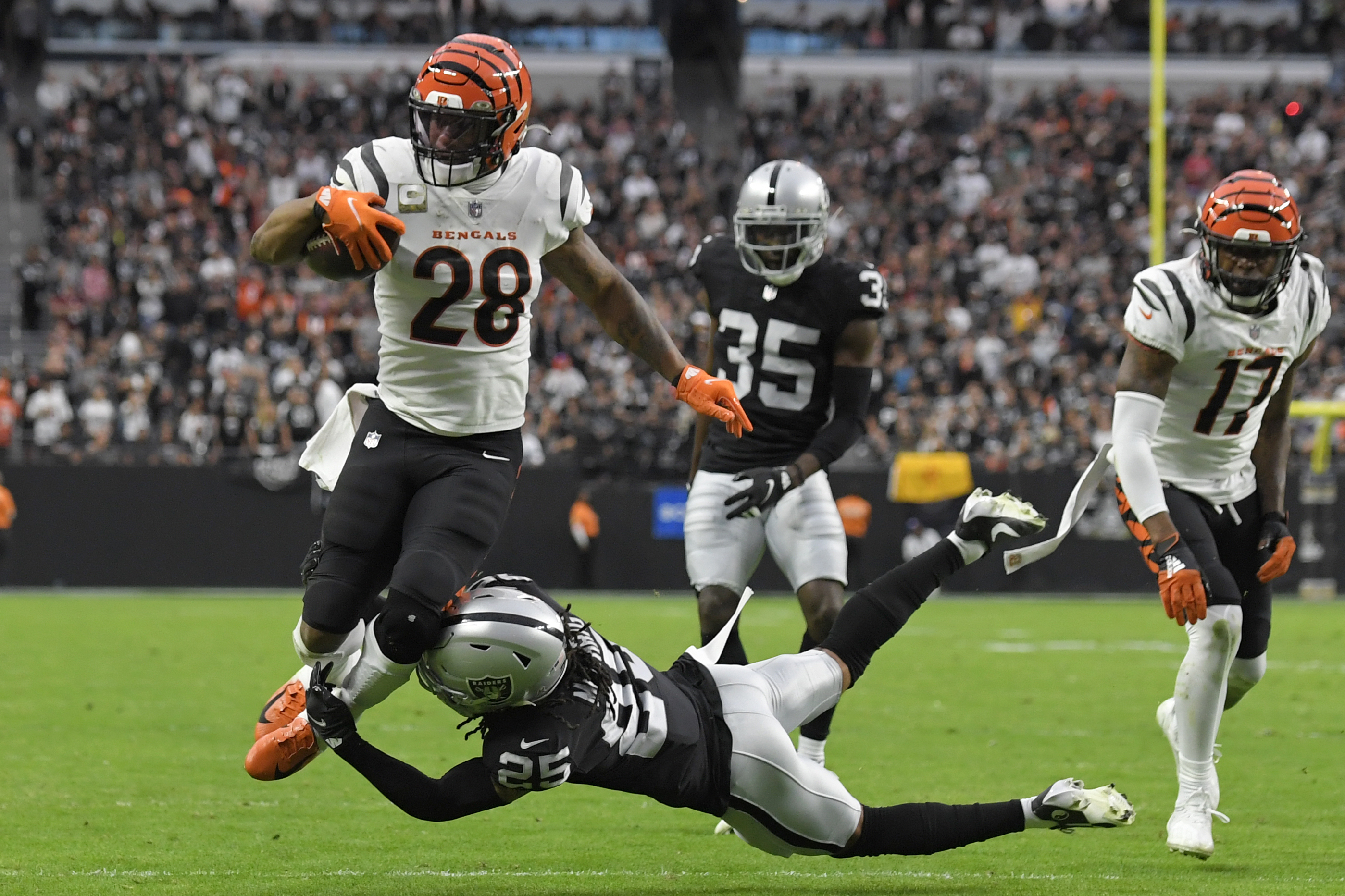 Cincinnati Bengals running back Joe Mixon (28) scores a touchdown against  Las Vegas Raiders free safety Trevon Moehrig (25) during the first half of  an NFL football game, Sunday, Nov. 21, 2021