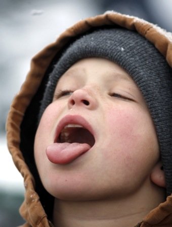 Steve Lopez, soon to be 13, of Englewood tries to catch snowflakes on his tongue Saturday, Dec. 4, while at the RiverScape MetroPark ice skating rink for a birthday celebration with his grandmother.