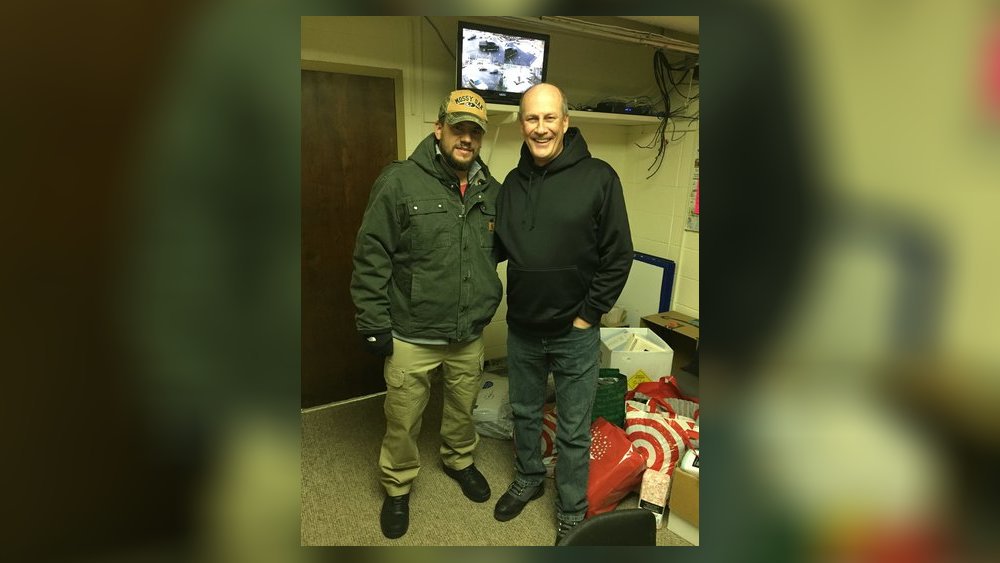 Bill Fugate (right), one of the coordinators at a Middletown church-based homeless shelter, was impressed that Kyle Schwarber, a fourth-year player for the Chicago Cubs, participated in his family’s donation to SHALOM. The Middletown family dropped off goods on Dec. 26 at the SHALOM office. Submitted photo