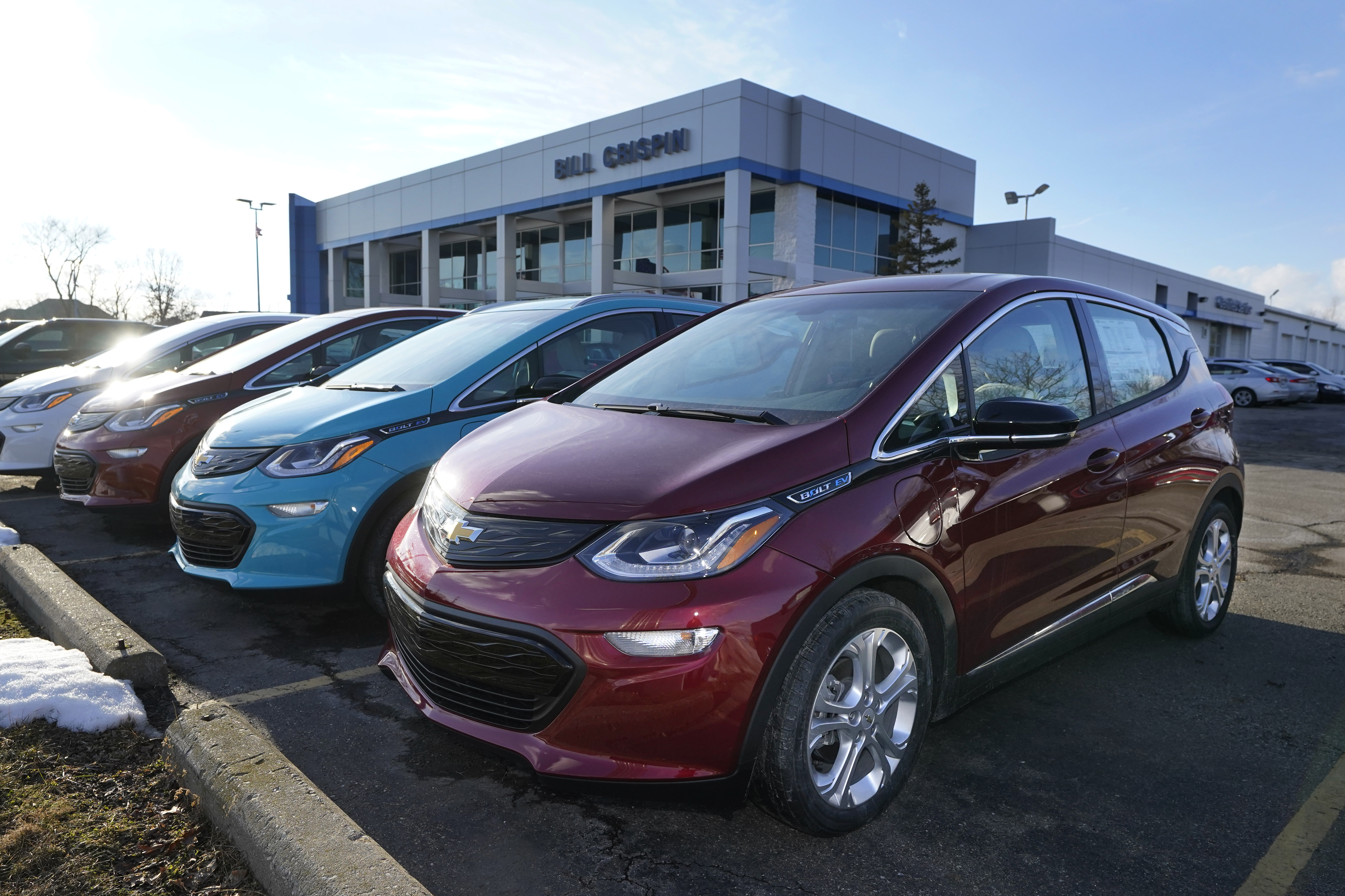 A 2021 Chevrolet Bolt EV, is displayed with 2020 models at Bill Crispin Chevrolet Thursday, Feb. 25, 2021, in Saline, Mich. Opinion polls show that most Americans would consider an EV if it cost less, there were more charging stations along freeways, and if automakers offered a bigger variety of models. (AP Photo/Carlos Osorio)