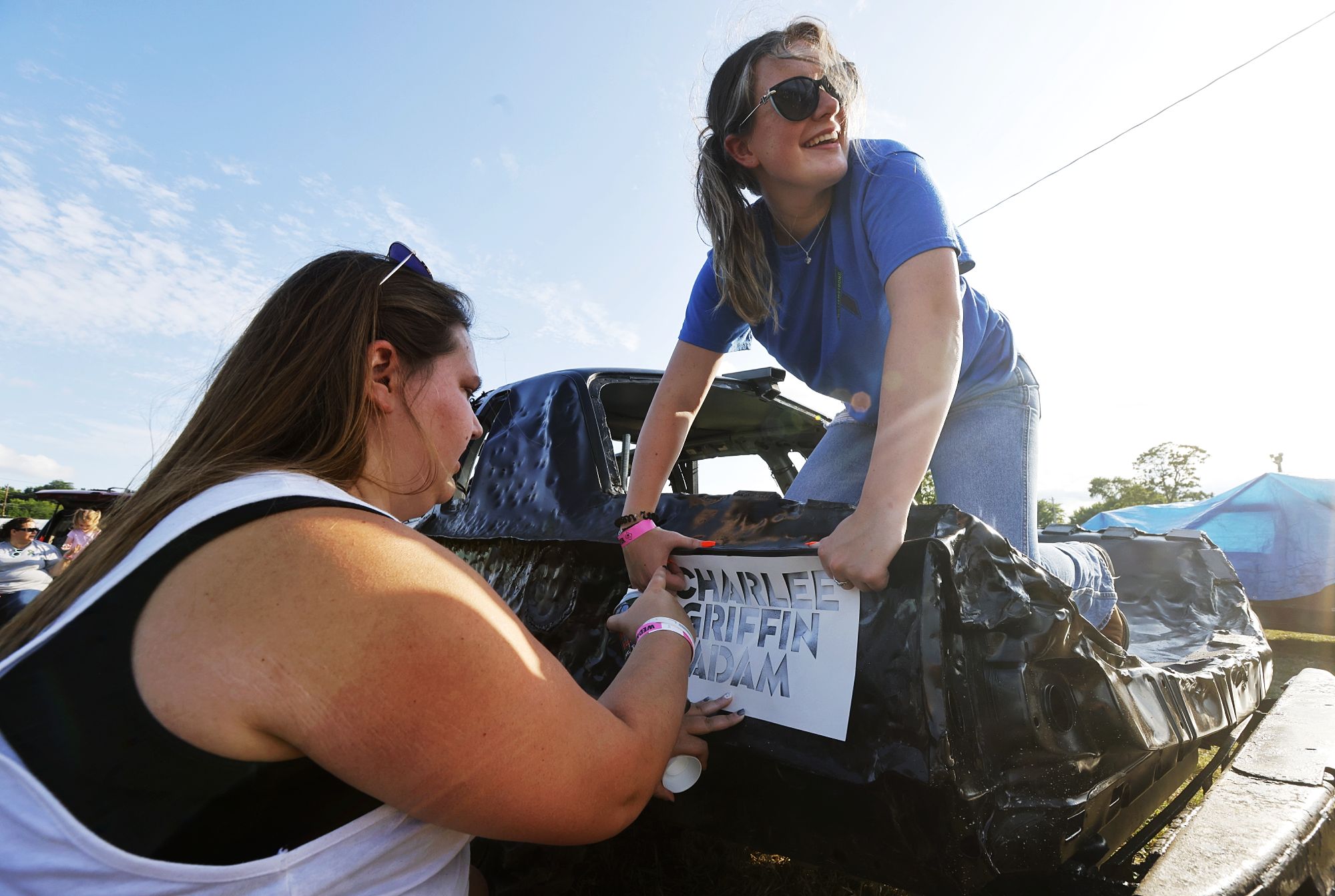Samantha Gray, left, and Ava Stone paint a car before the demolition derby at the Butler County Fair Wednesday, July 27, 2022. NICK GRAHAM/STAFF